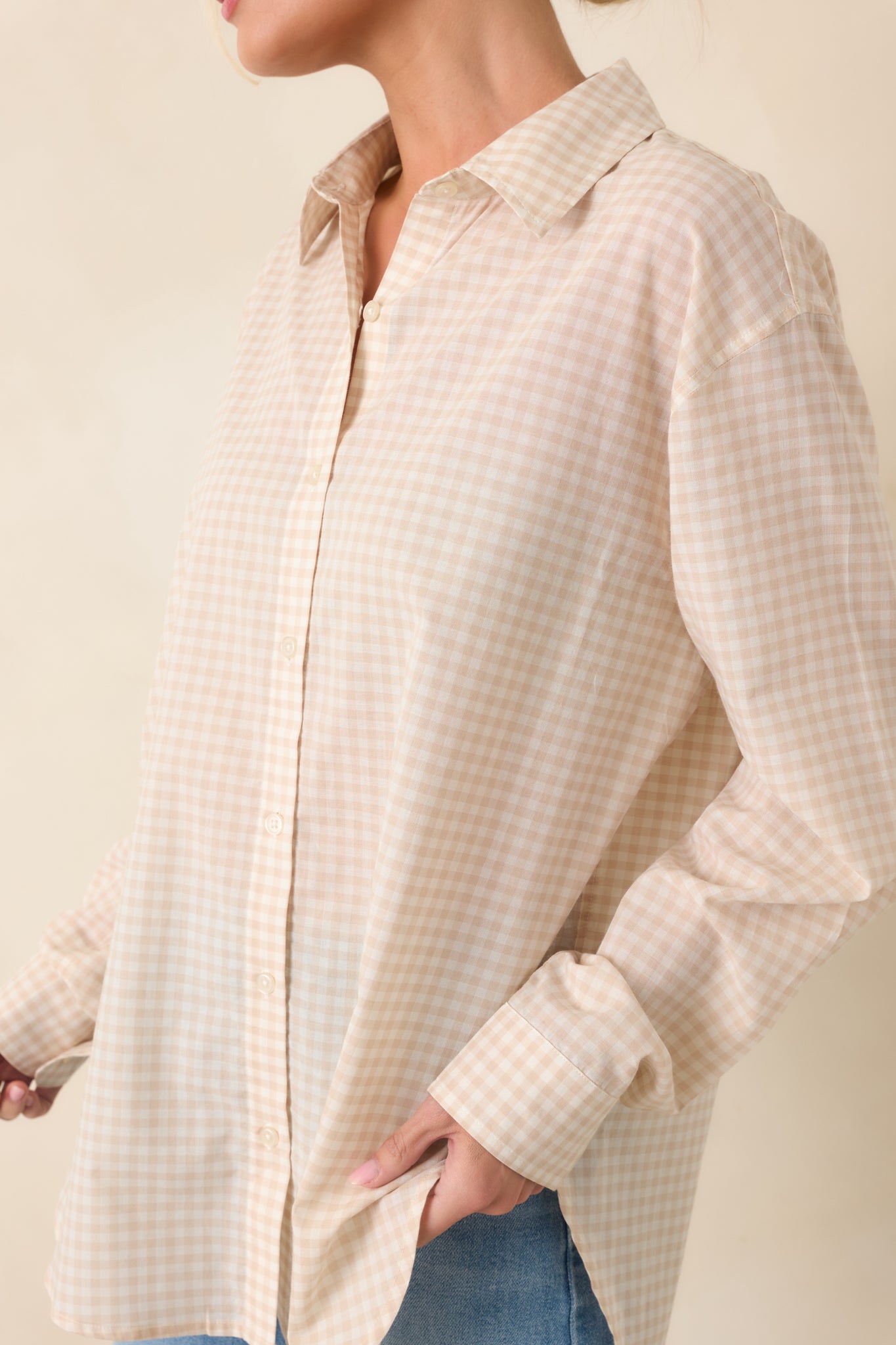 Beige gingham shirt detail showing the full button closure and lightweight fabric.