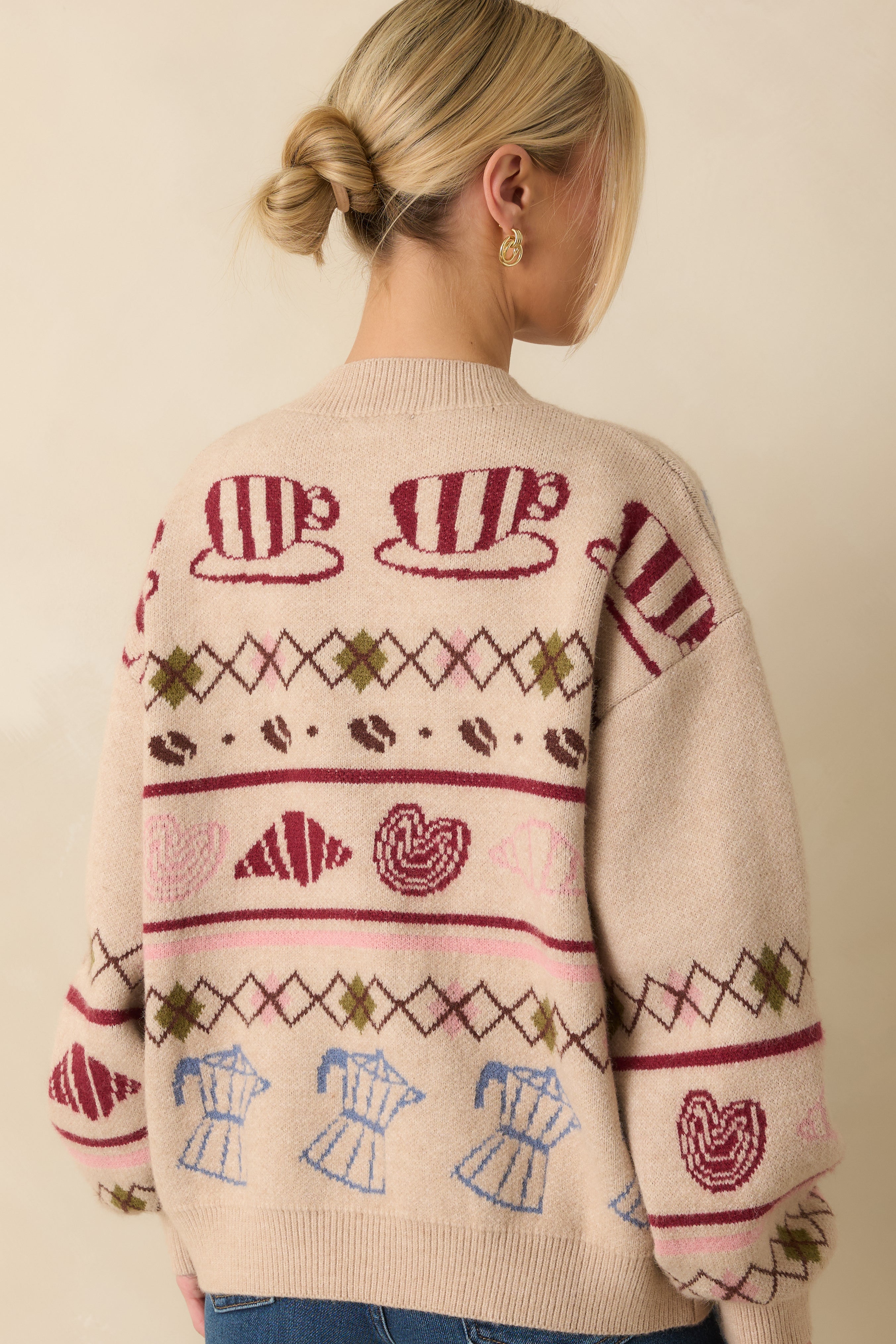 Rear view of the beige knit cardigan showing the overall motif pattern and relaxed, ribbed-hem finish.