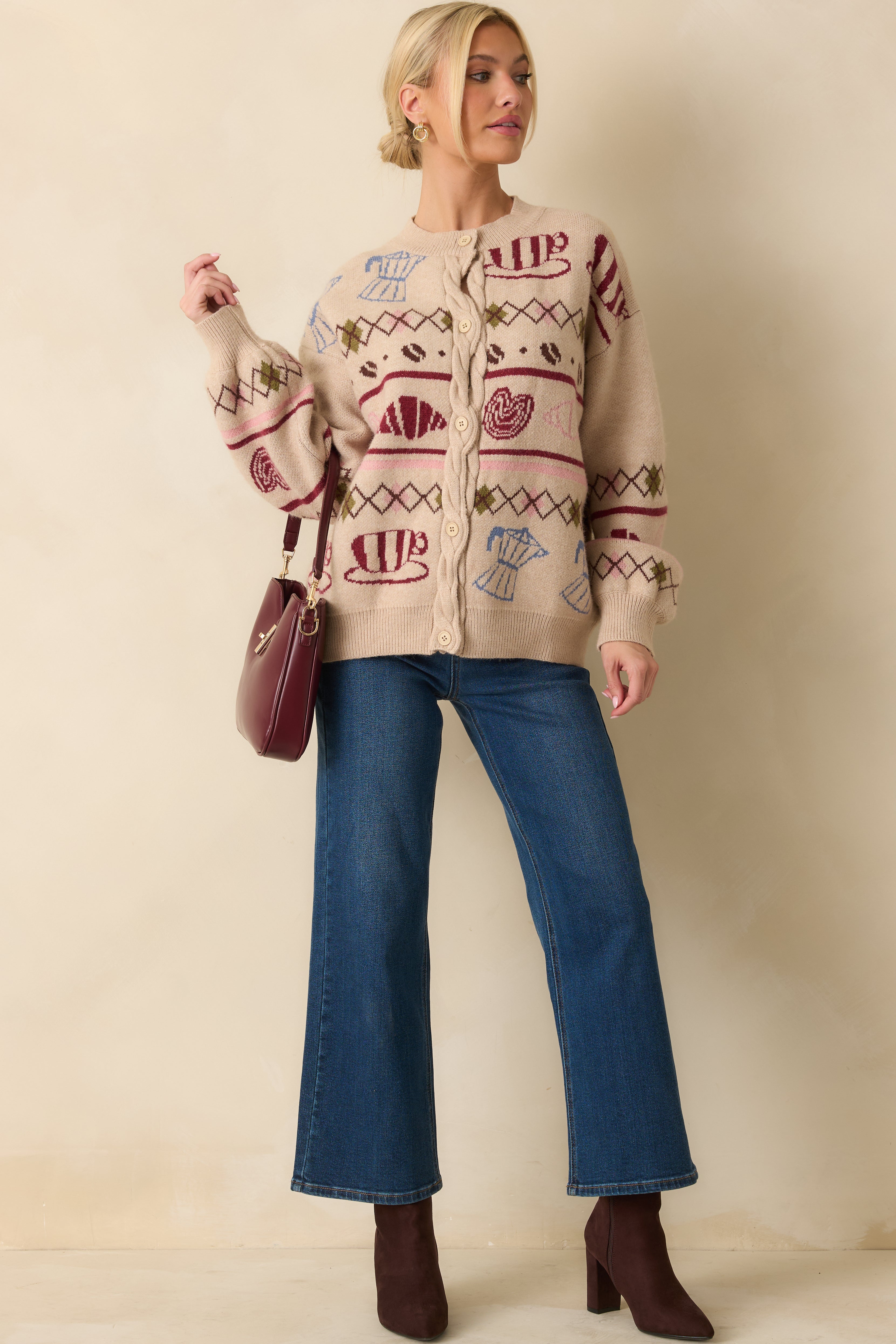 Knit cardigan in beige tones highlighting the whimsical motif and softly draped silhouette.