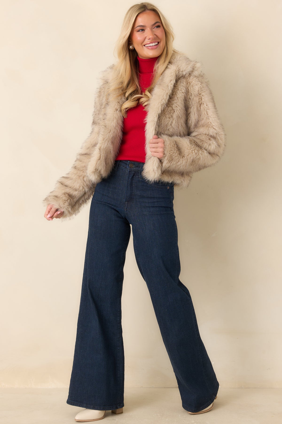 Beige long-pile faux fur jacket featuring a voluminous silhouette, full-length sleeves, and overlapping front panels.