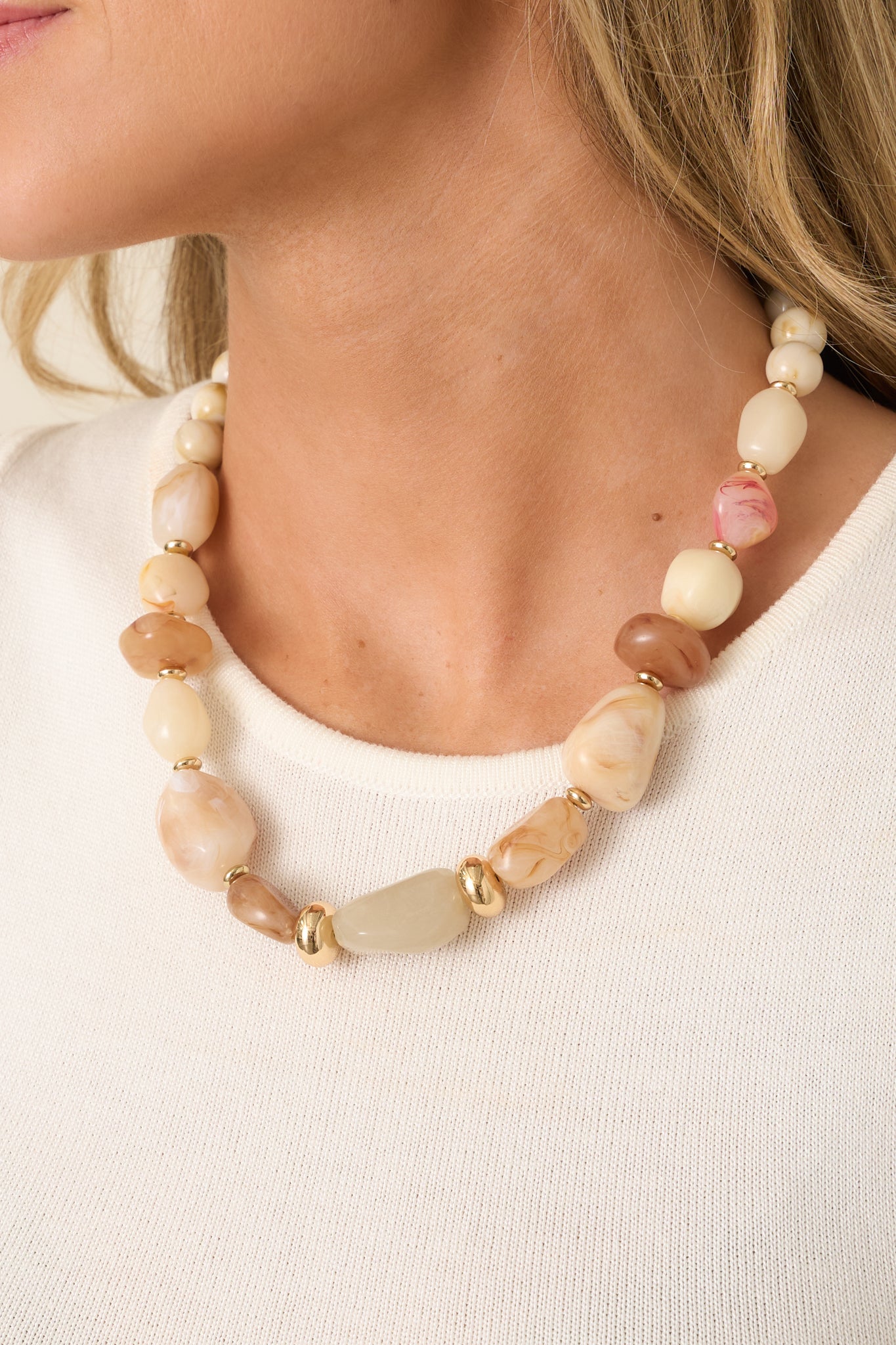 Mixed bead necklace featuring creamy ivory, beige, and caramel beads with polished gold-tone spacers for a balanced neutral design.