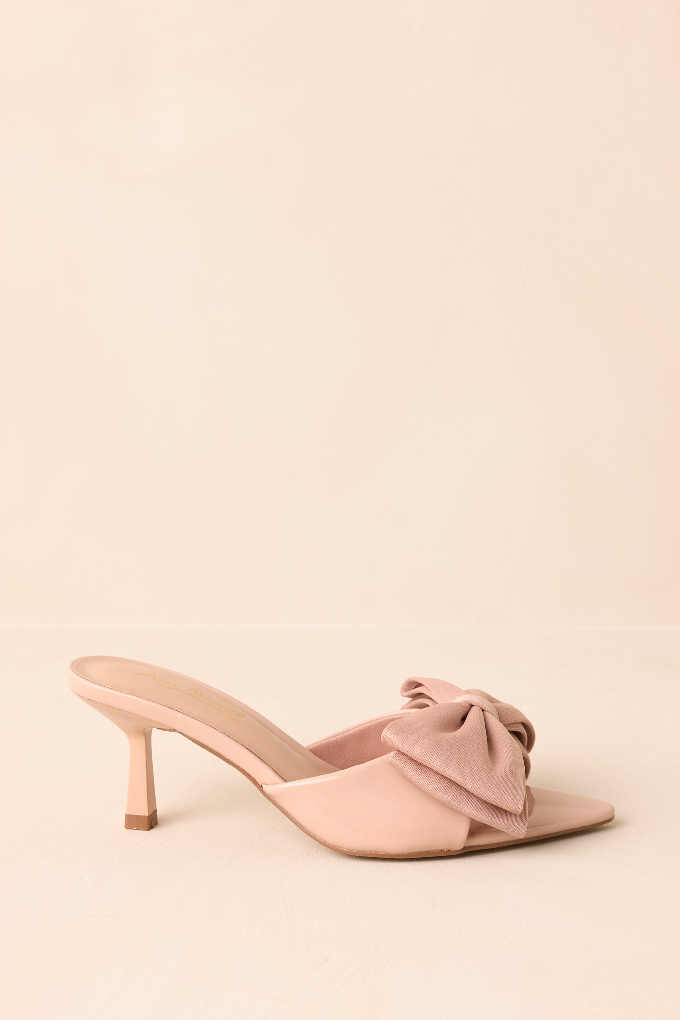Side profile of the beige mule heel showing the slim kitten heel.