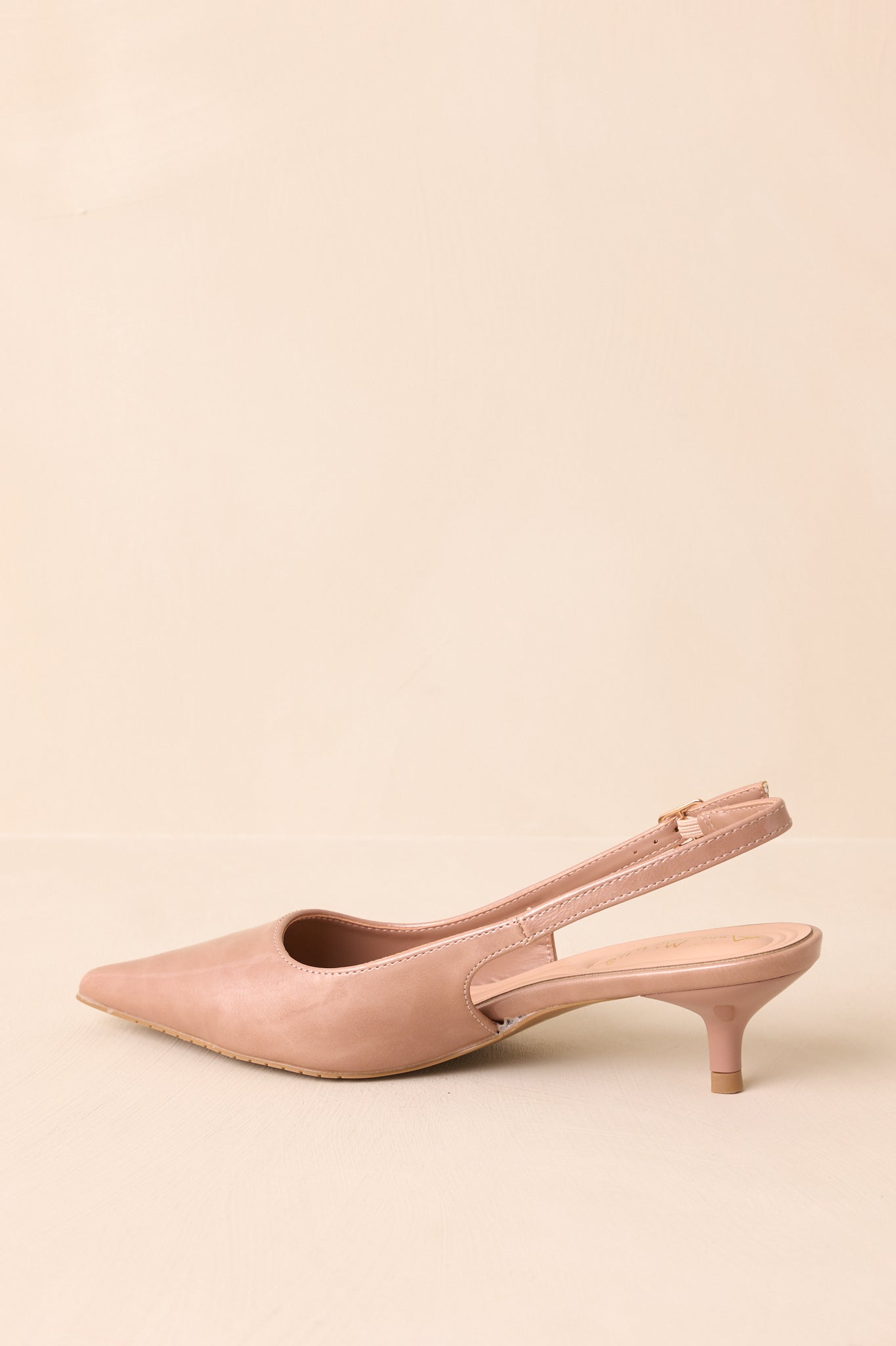 Rear view of the beige patent slingback heels highlighting the slim heel and back strap.