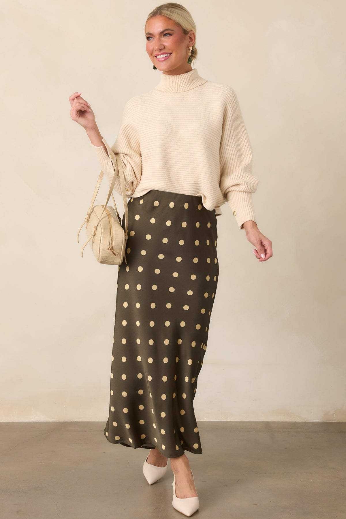 Beige pullover sweater combining a cozy ribbed texture with a draped batwing shape and cropped silhouette.