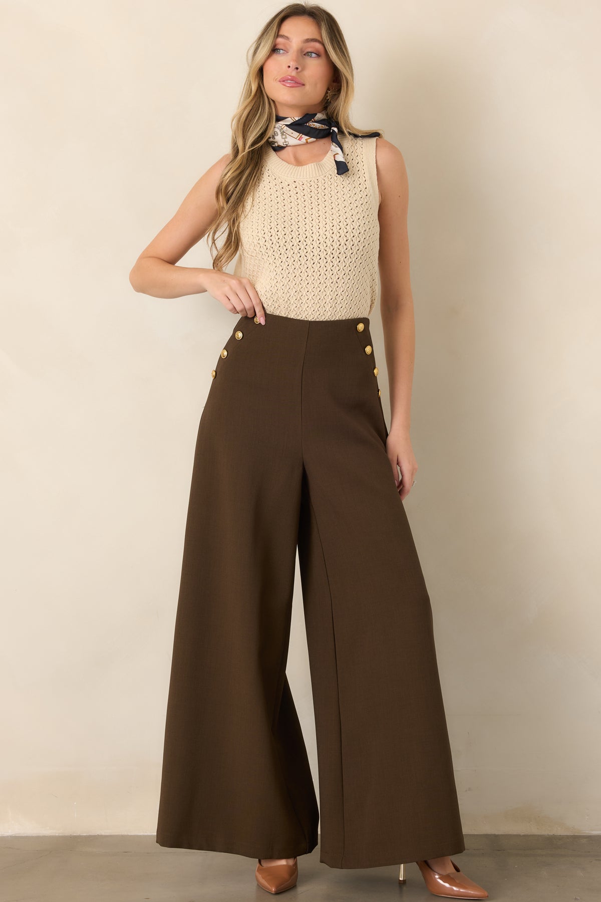 Beige open-knit top with a relaxed sleeveless shape, clean round collar, and textured ribbed finishing at the edges.