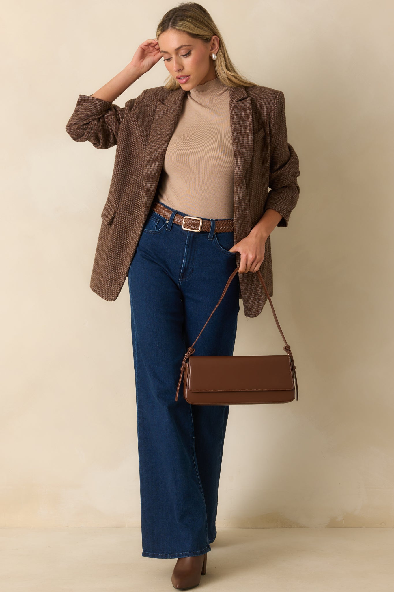 Model posing in beige wide leg pants and mock neck top.