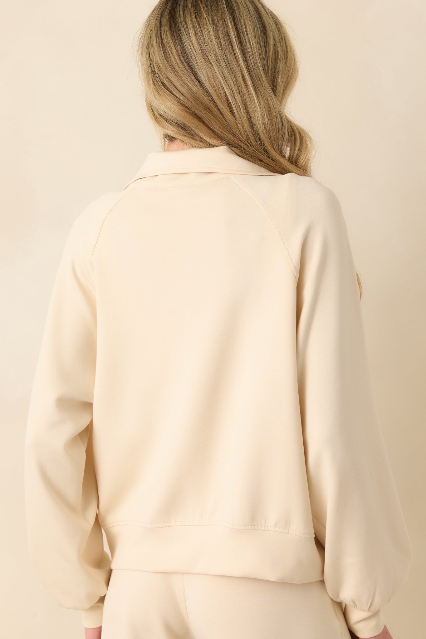 A back view of the jacket showing the structure of the collar, relaxed fit, and continuation of the thick hem across the back.