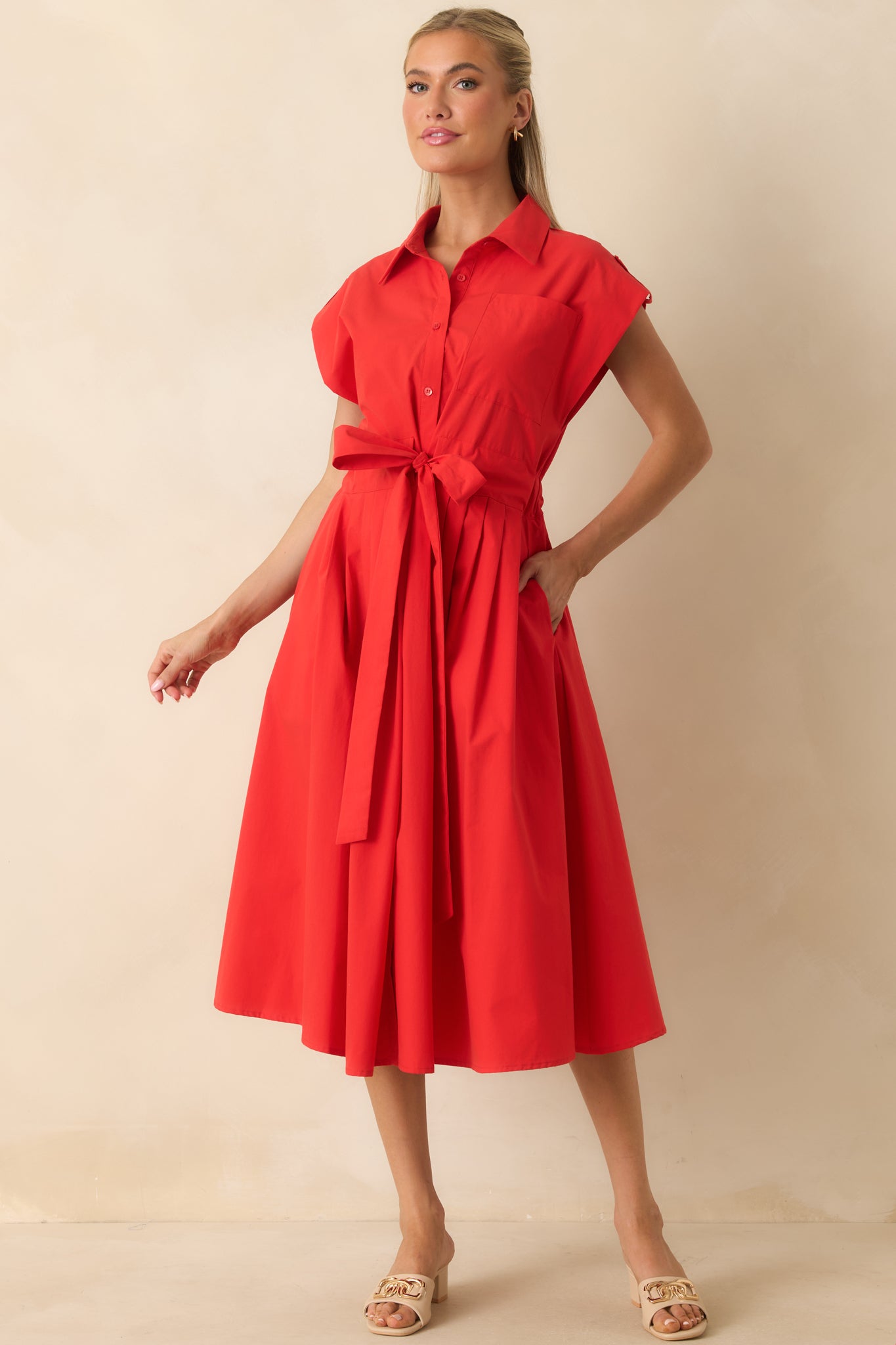Polished midi dress with a belted waist, structured collar, functional side pockets, and flowing pleated skirt.