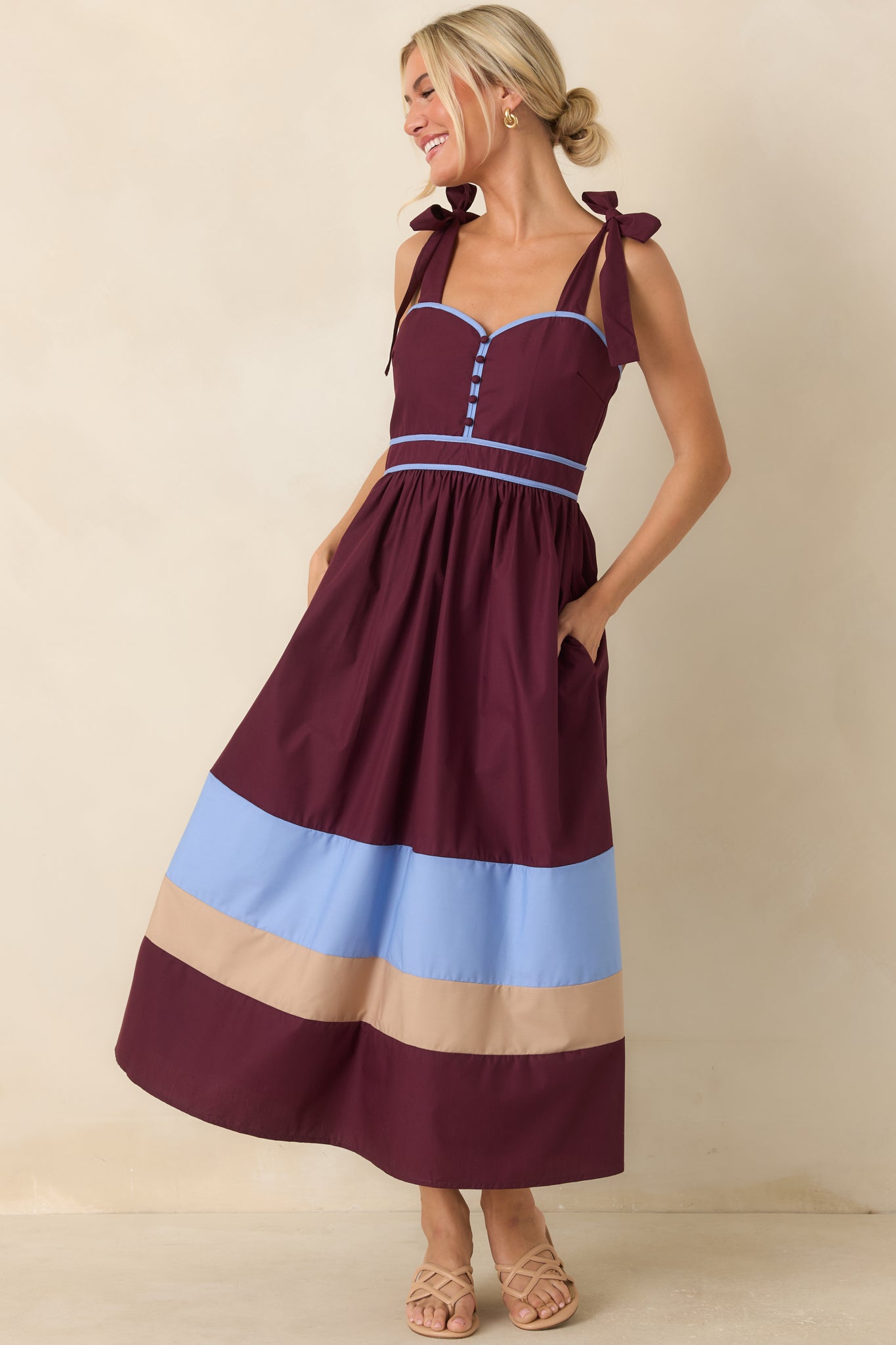 Statement berry dress showcasing powder blue accents, warm beige trim, covered buttons, and a flowing gathered midi skirt.
