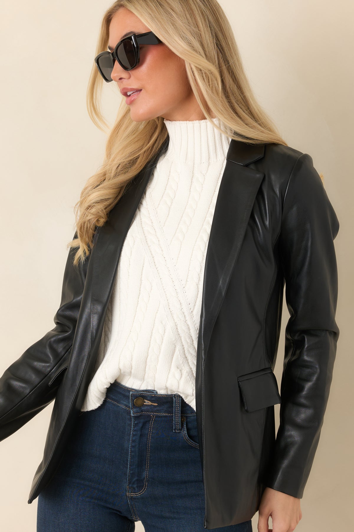 Tailored front panels and notched lapels create a polished look on the black faux leather blazer.