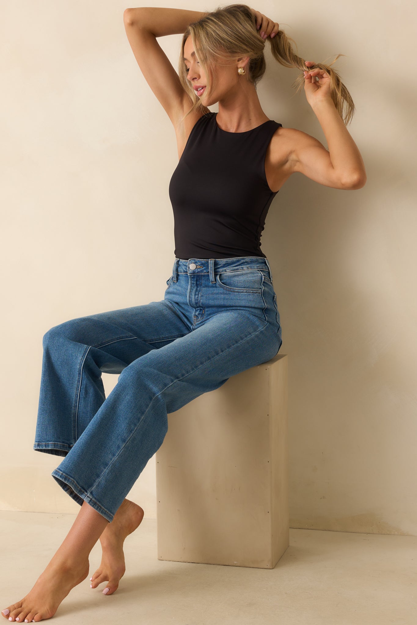 The black bodysuit showing its smooth stretch-knit finish and clean high crew neckline.