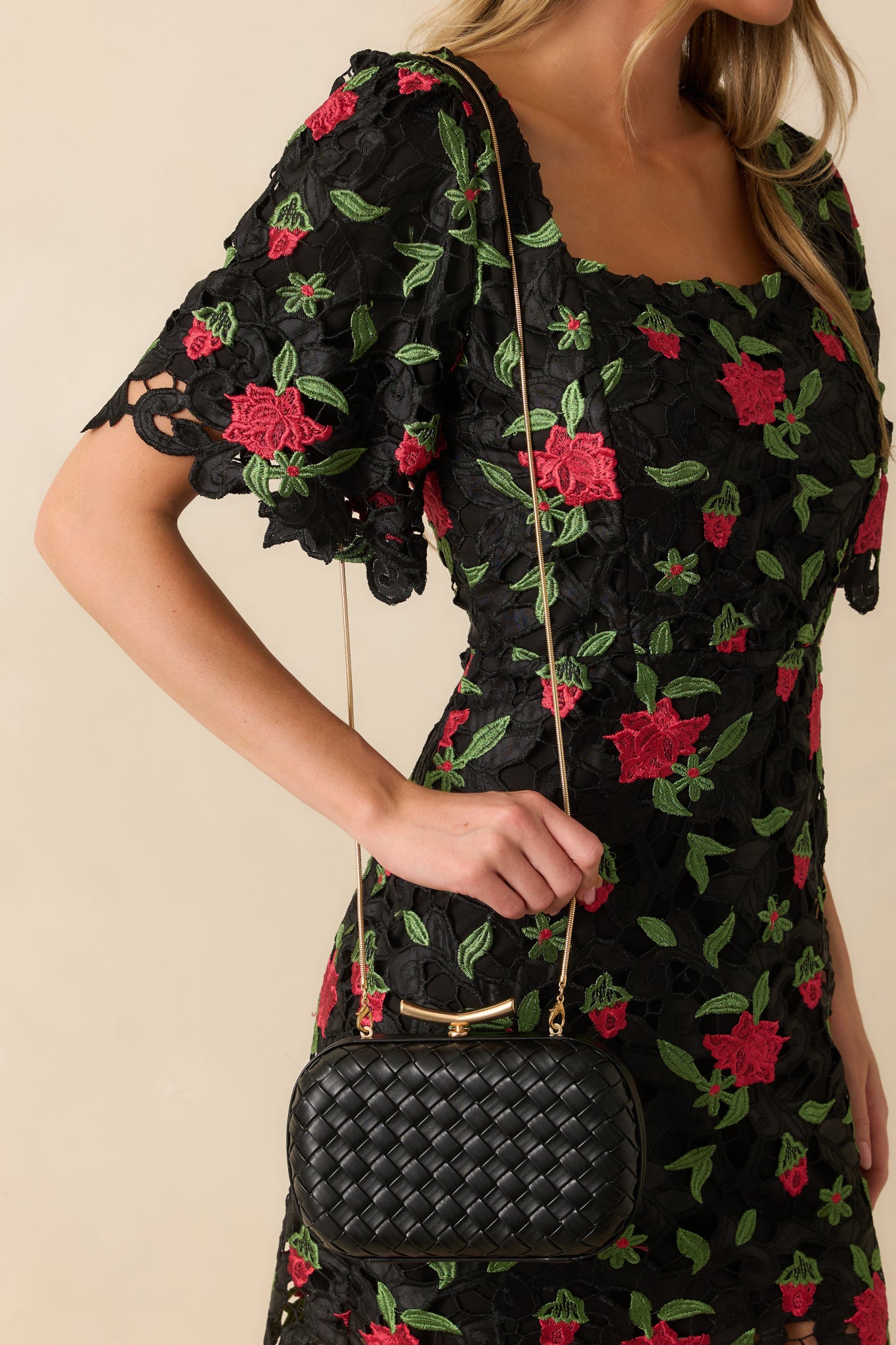 The black clutch displayed in full view highlighting the polished top bar clasp closure and optional snake chain strap.