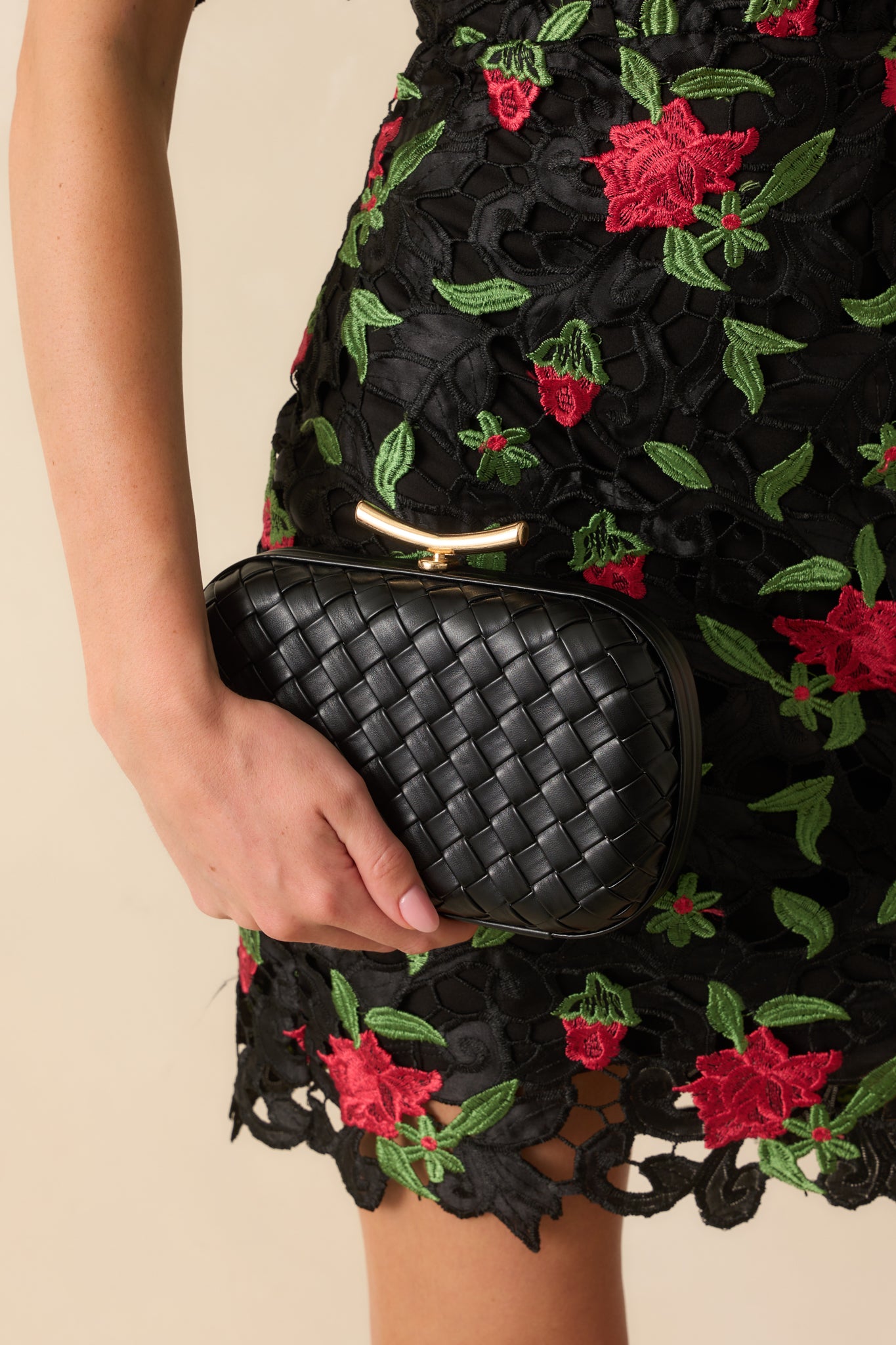 A full view of the black clutch showing the structured rectangle shape with rounded corners and hard-shell frame.