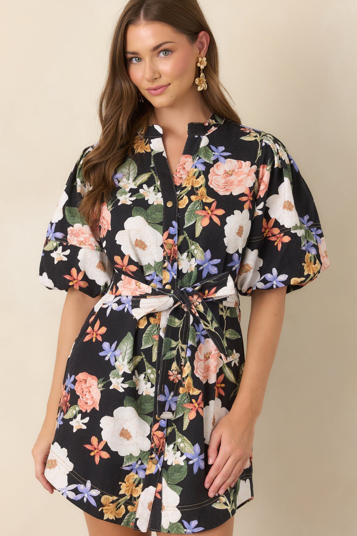 Black mini dress featuring coral, ivory, lavender, and golden yellow florals with a softly relaxed silhouette.