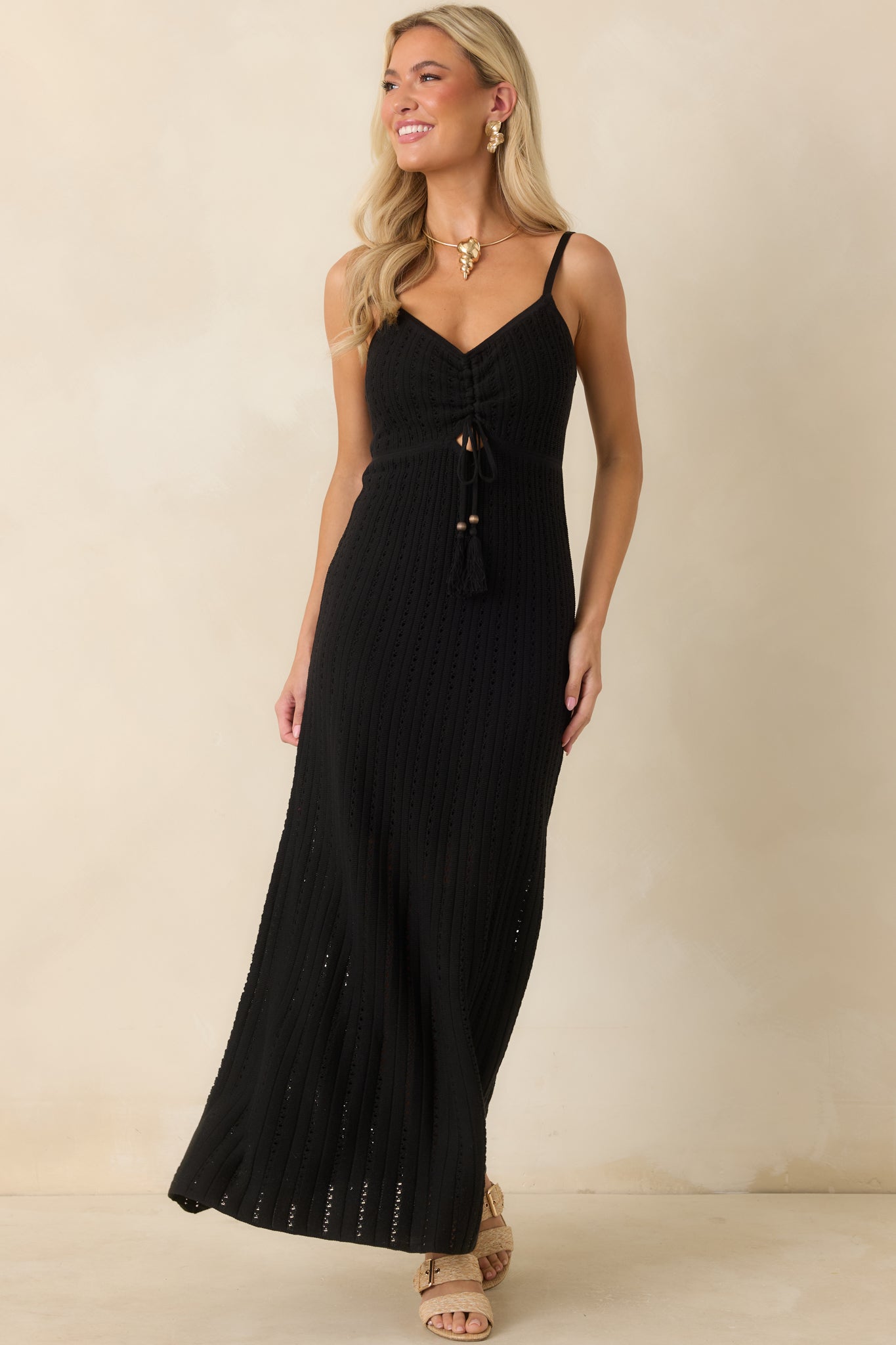 Black crochet maxi dress featuring adjustable spaghetti straps, a flattering V-neckline, and a fitted silhouette with an open-knit design.
