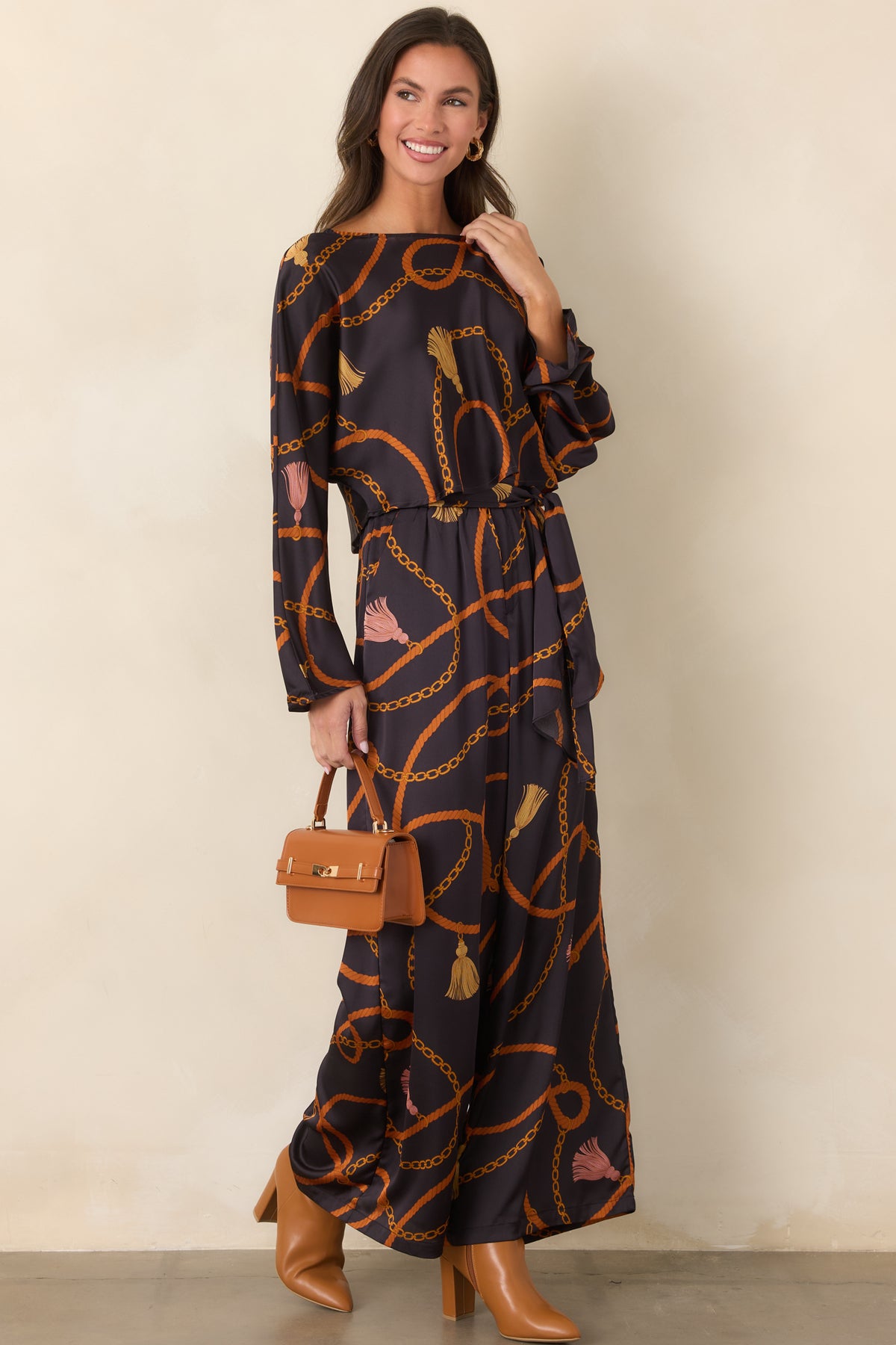 Cropped black top with an ornate rust rope and gold chain pattern, finished with a relaxed silhouette and full-length sleeves.