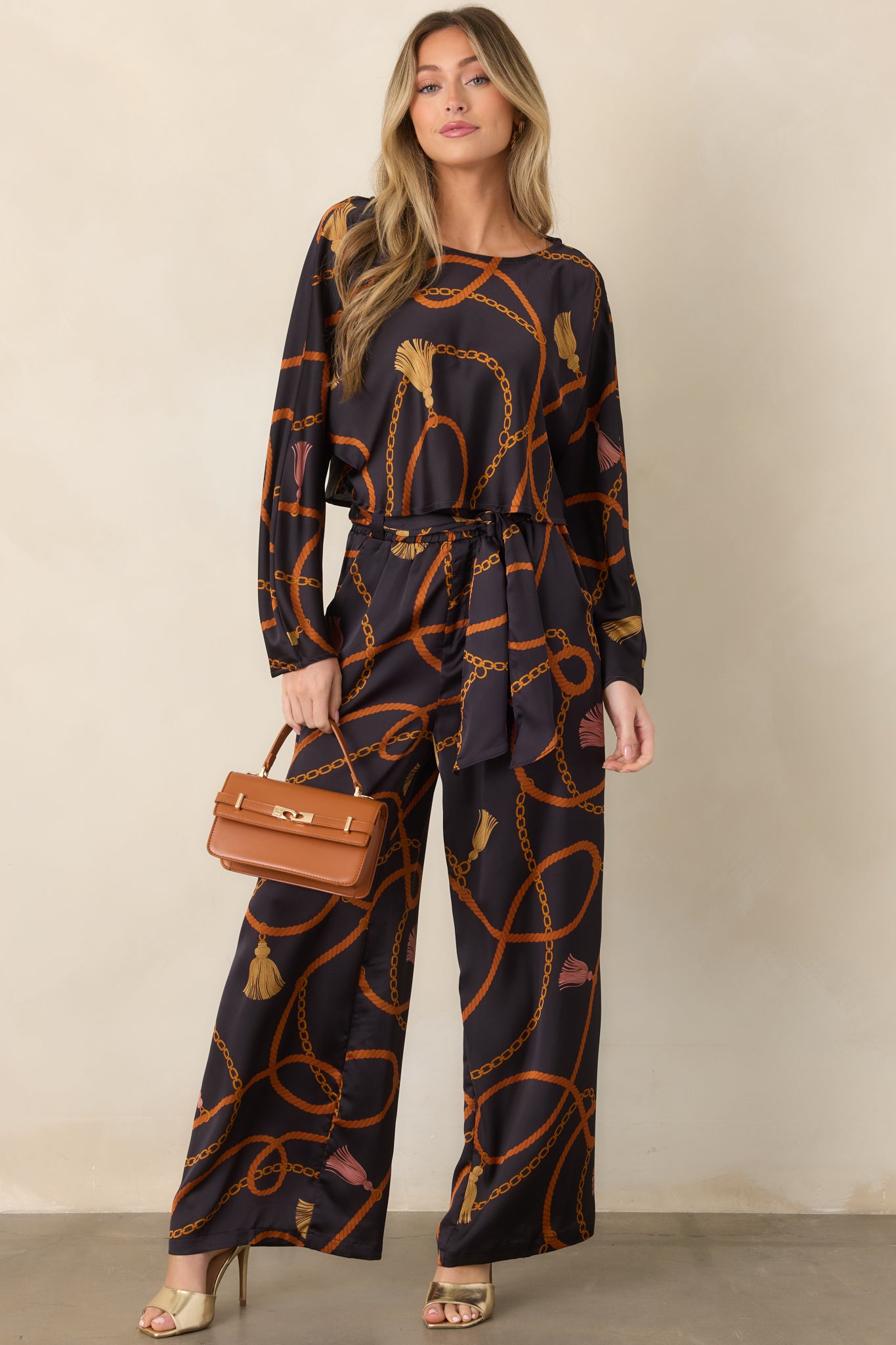 Relaxed cropped top showcasing a rich black background with looping rust ropes and golden chain motifs.