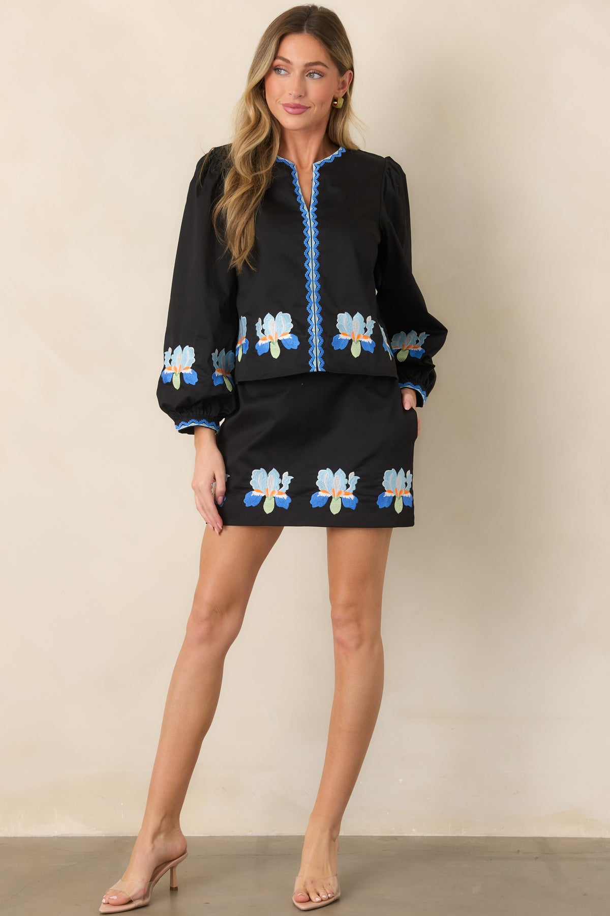 Black embroidered blouse showcasing a split neckline and voluminous puff sleeves.
