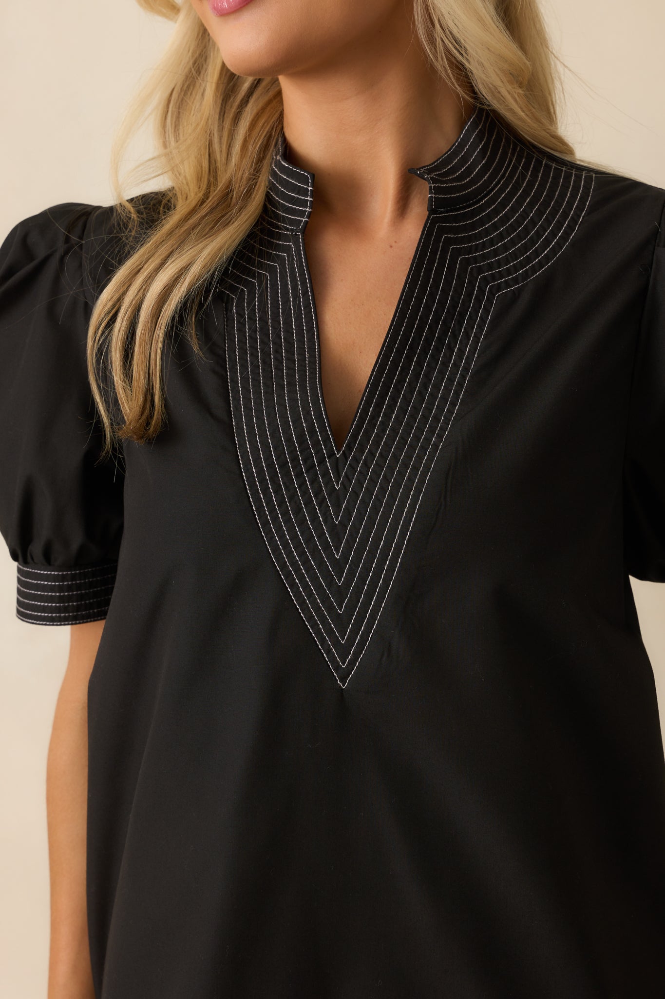 White topstitching accent on black fabric showing texture and craftsmanship.