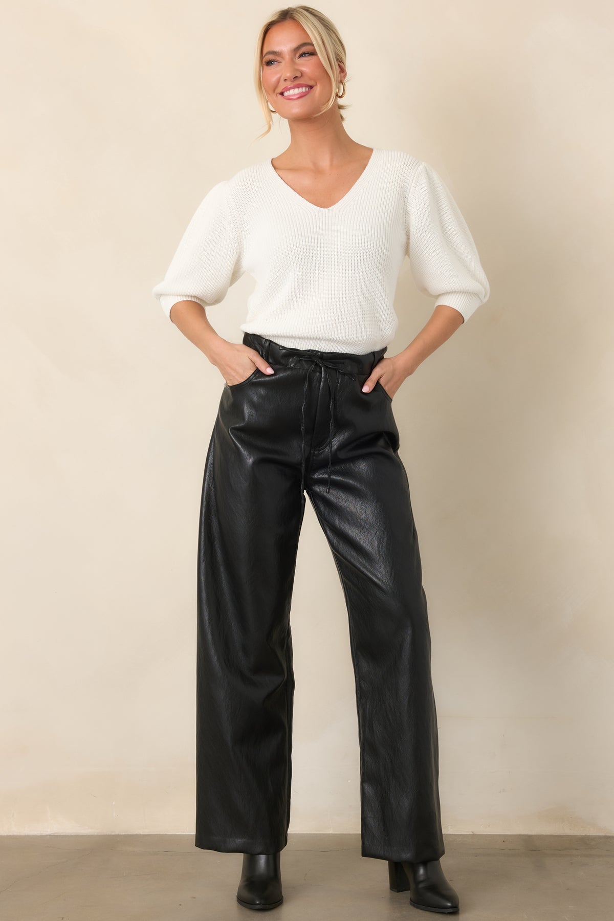 Black faux leather pants featuring a high-rise waist, straight wide-leg cut, and elastic waistband with drawstring tie.