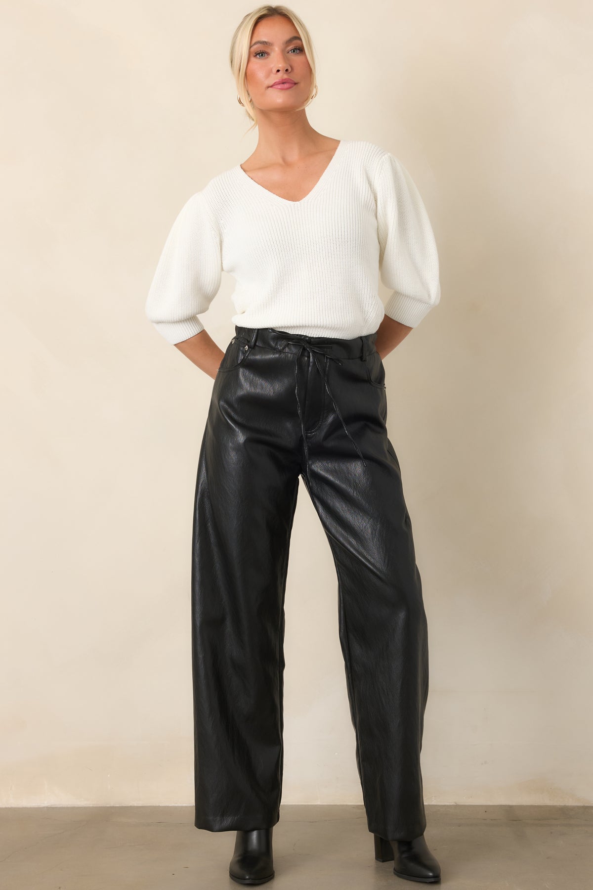 Black faux leather pants showcasing the relaxed wide-leg silhouette, high-rise fit, and comfortable elastic waistband.