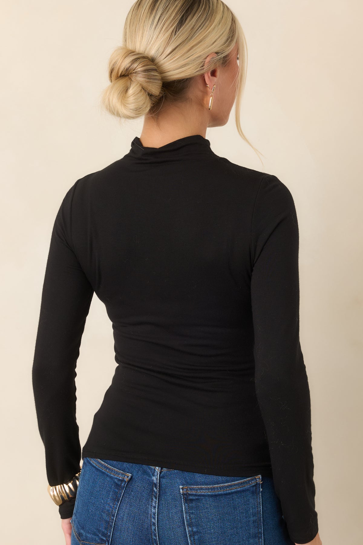 Rear of the black fitted knit top showing the smooth rayon-blend fabric and long sleeves.