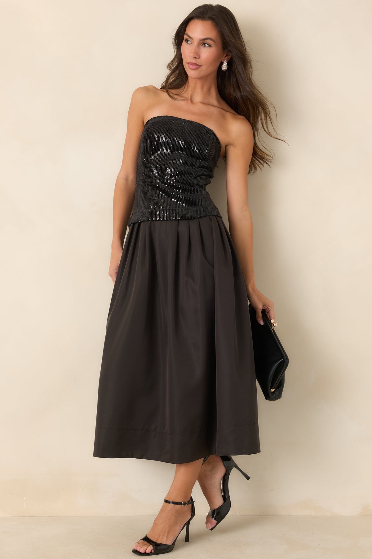 Black midi dress featuring a fitted sequin top and dramatically full pleated skirt.
