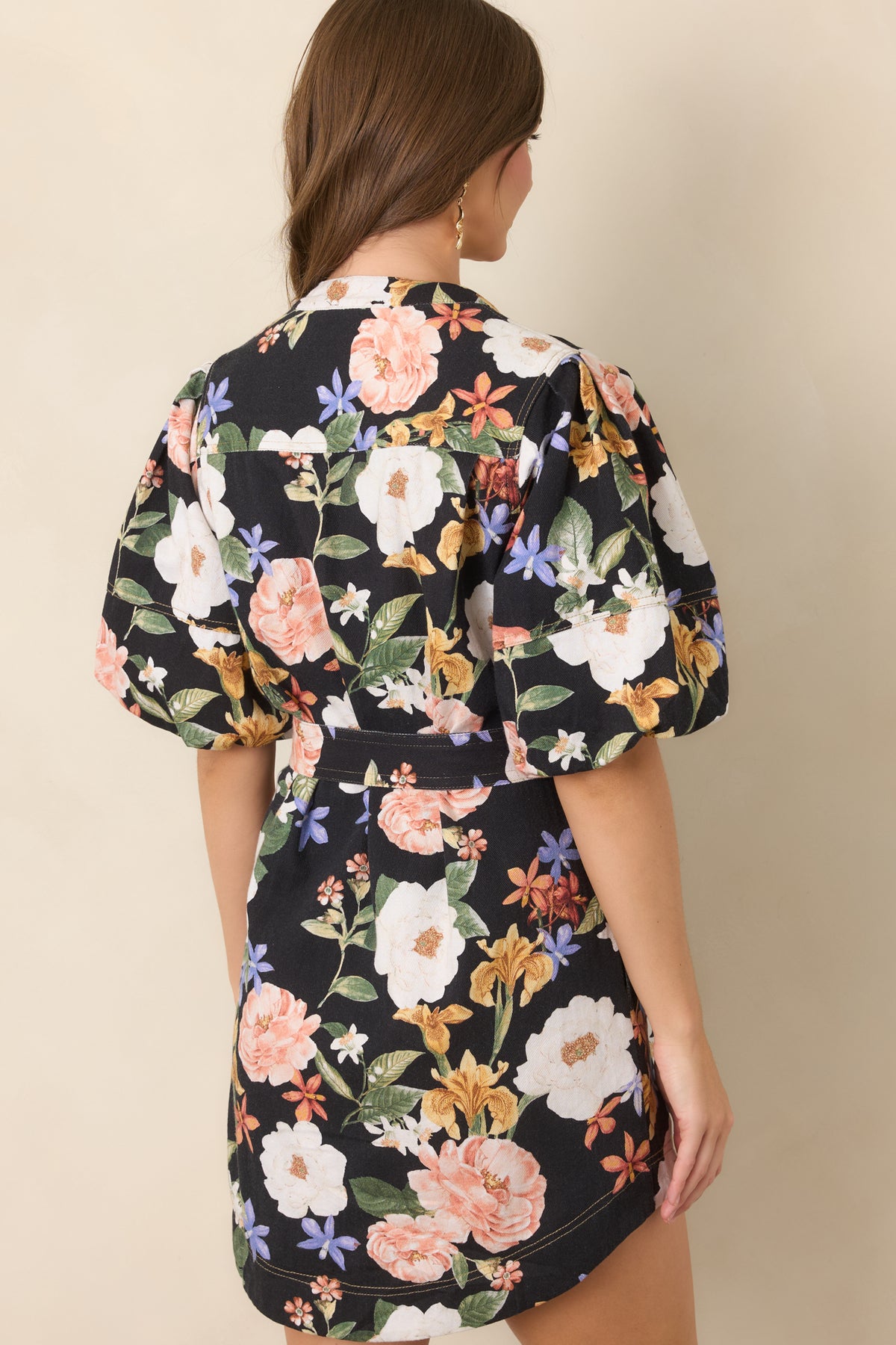 Rear of the black floral mini dress showcasing the colorful floral print and relaxed silhouette with voluminous sleeves.
