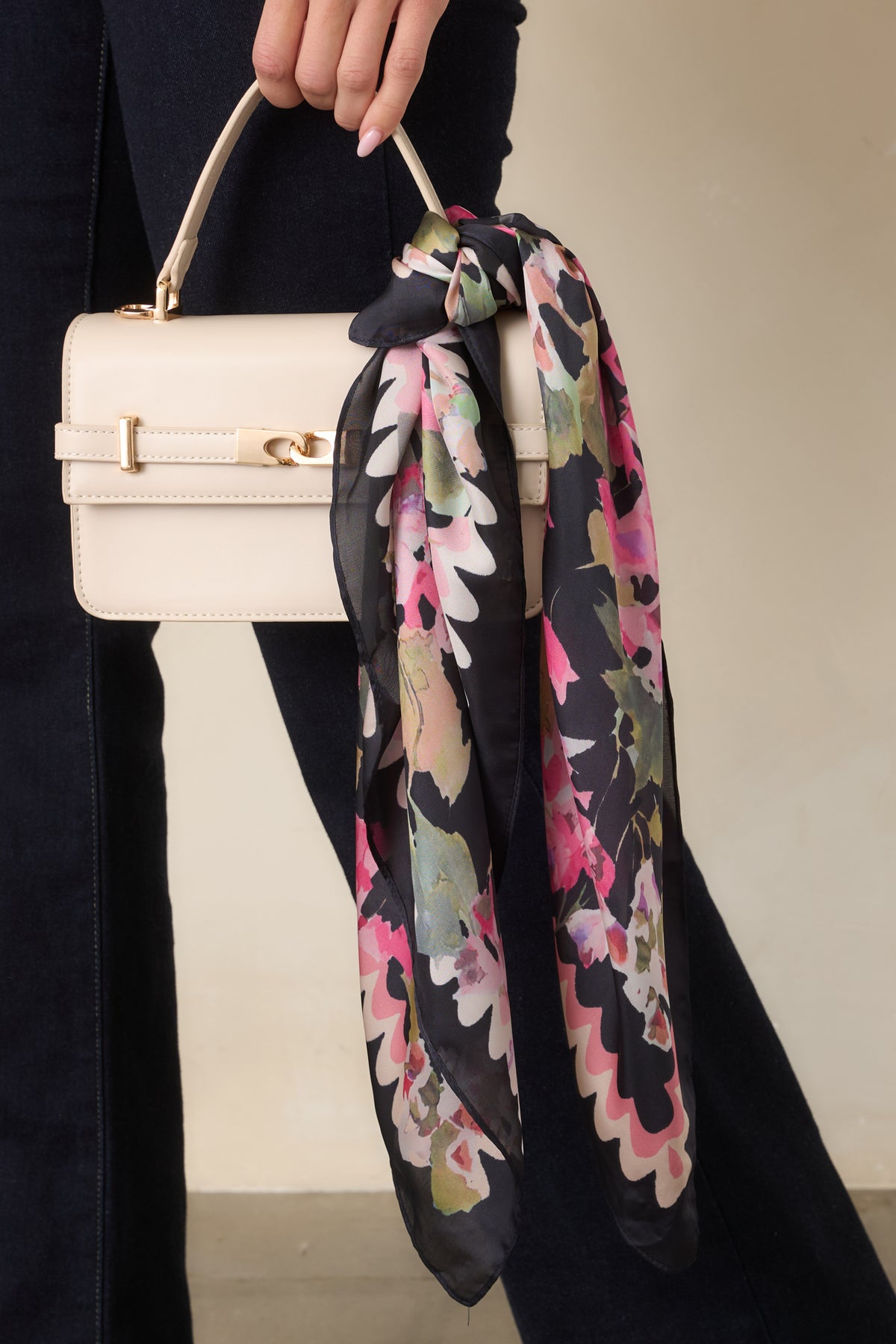 Black hair scarf featuring painterly pink, ivory, and green blooms with a decorative scalloped border.