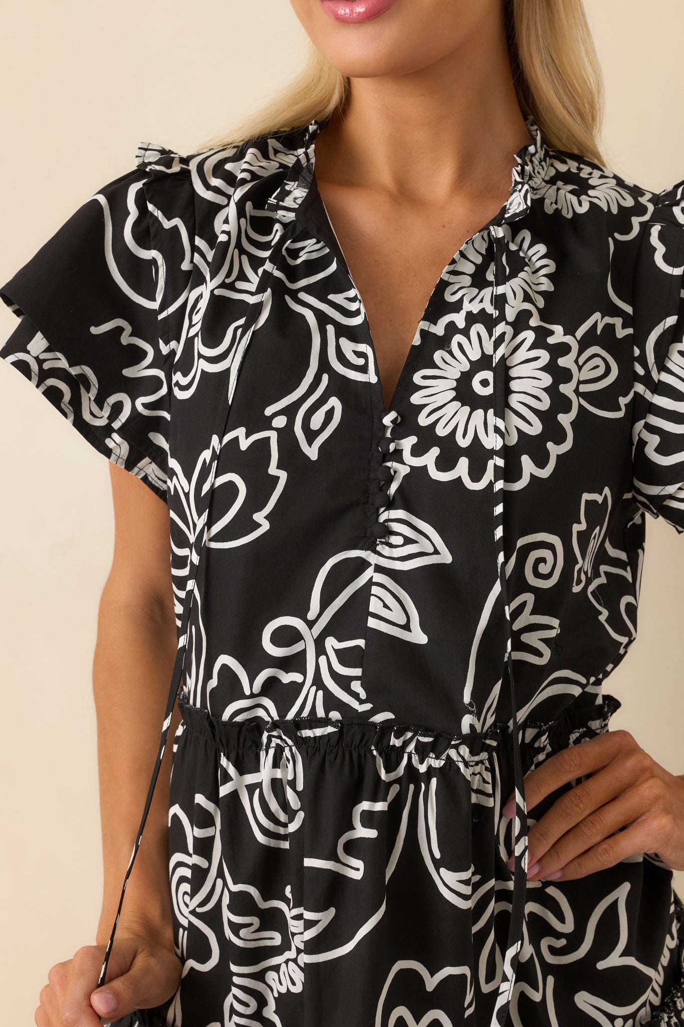 A detailed close-up capturing the texture of the fabric and the intricacy of the white floral print against the black background.