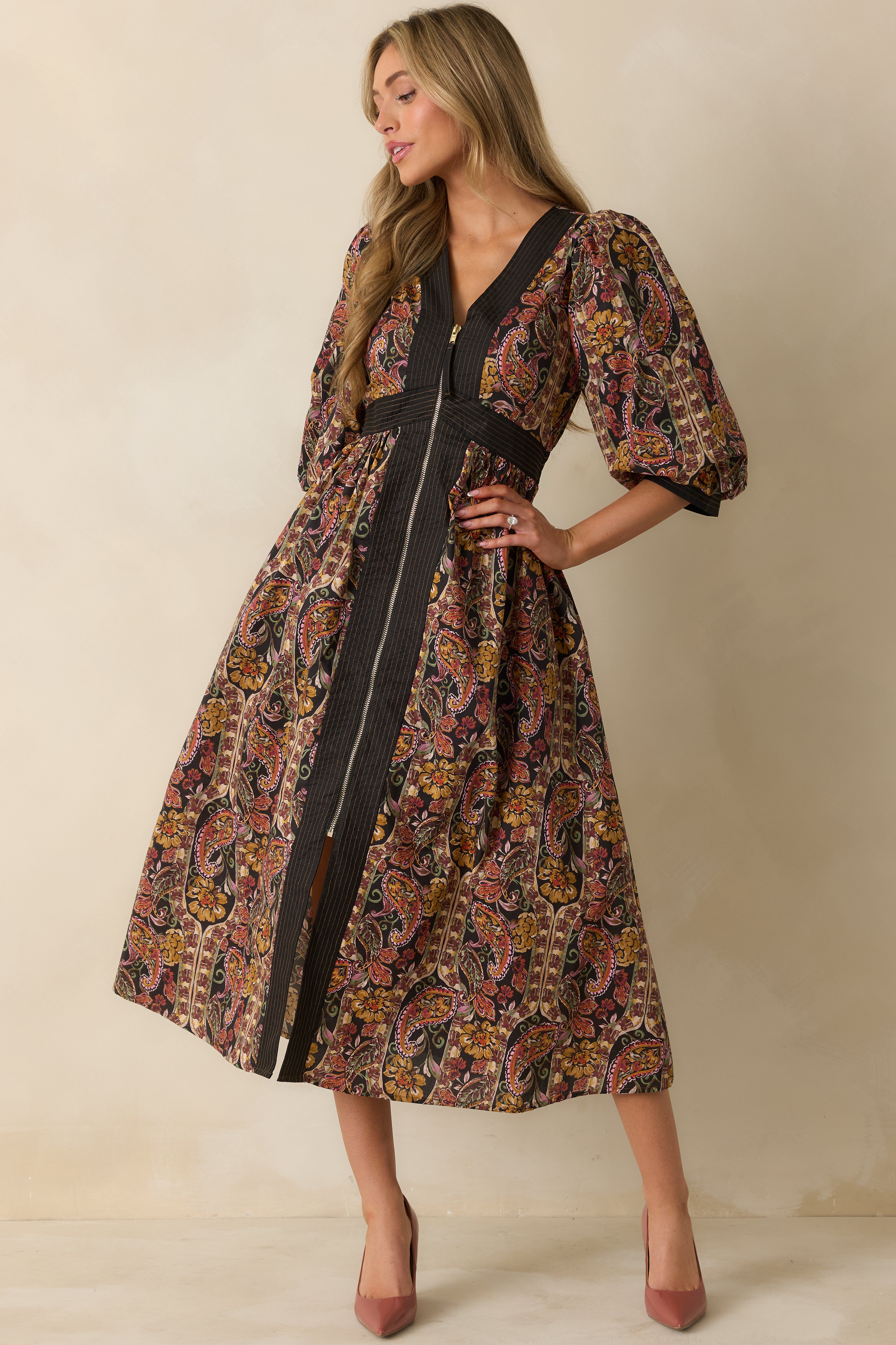 Maxi dress featuring a fitted waist with striped detailing and side pockets in black floral print.