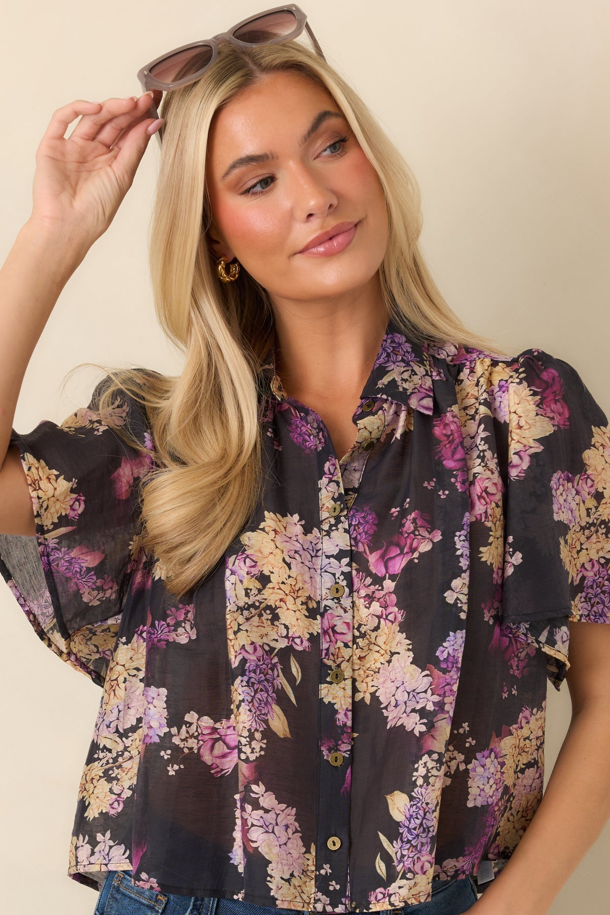Gentle gathers at the shoulders create subtle volume across the lightweight black floral top.
