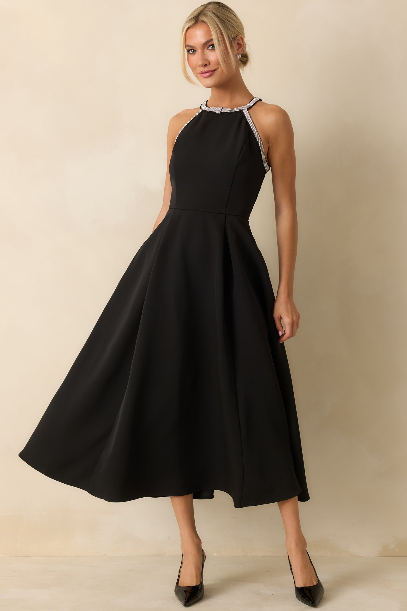 Black halter midi dress with a sparkling rhinestone-trim neckline, tailored bodice, and elegant pleated A-line skirt for a polished finish.