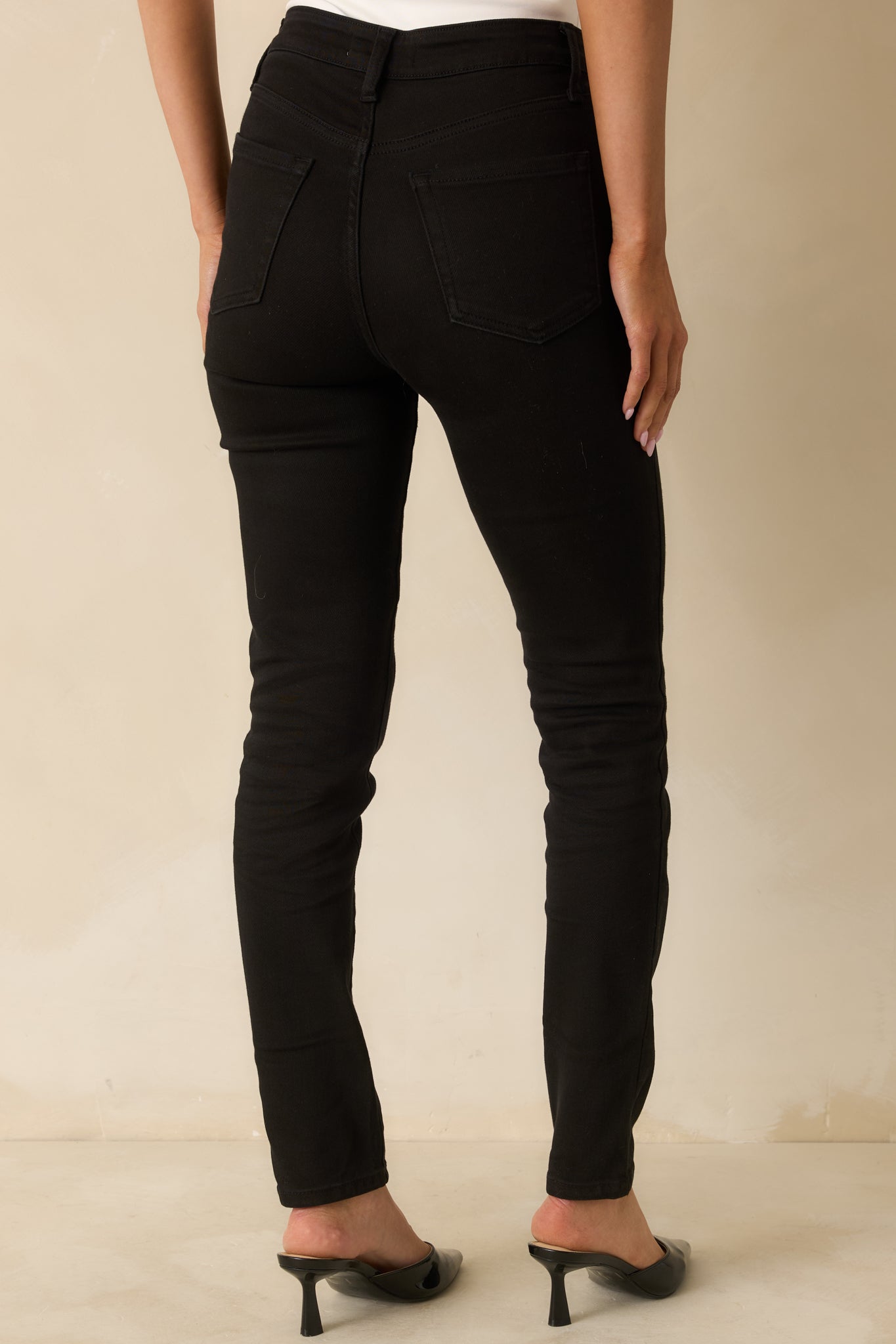 Back view of the black high-rise jeans showing the contoured seams and classic back pockets.