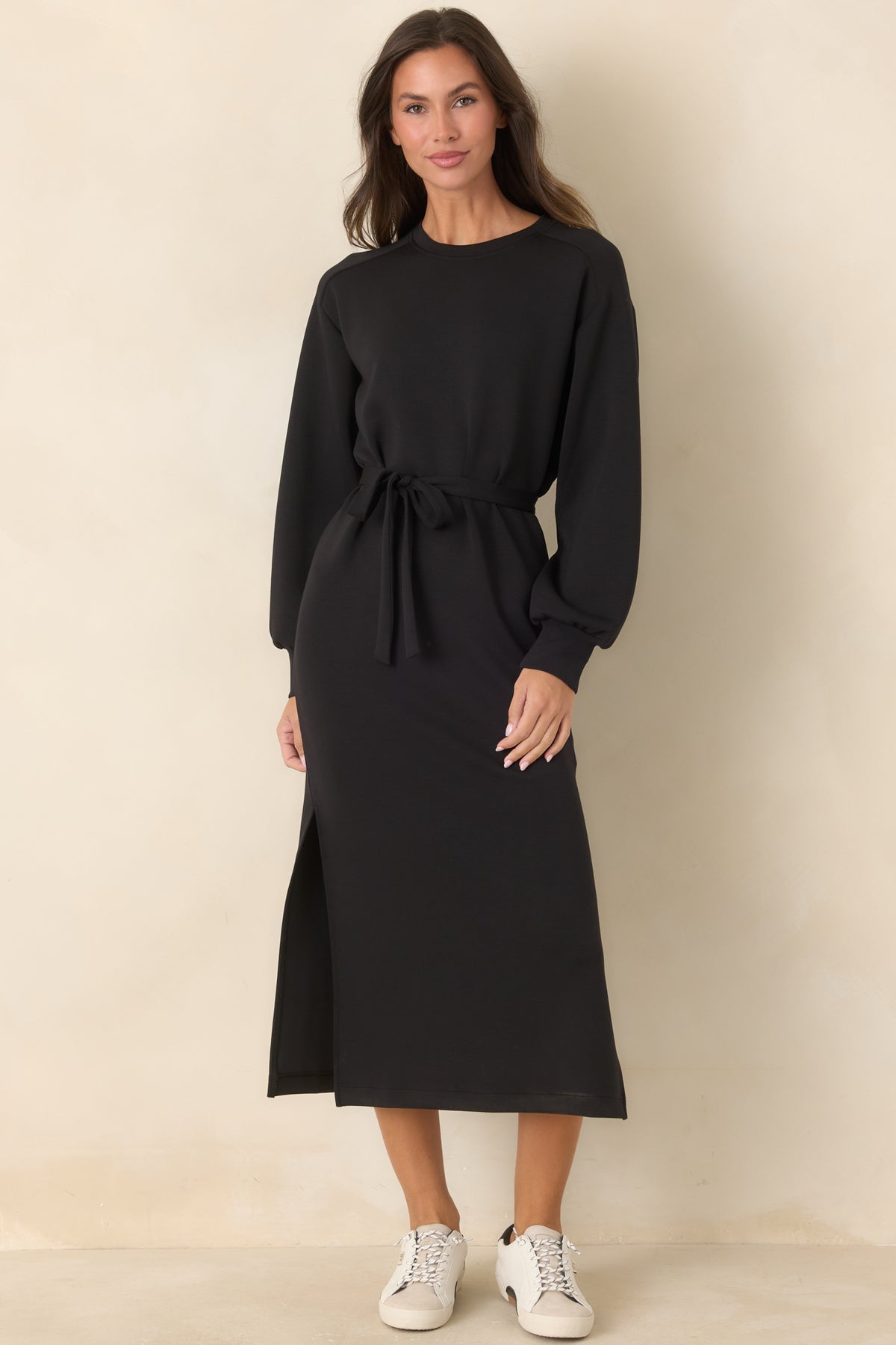 Long-sleeve black midi dress with a relaxed shape and side slits for added movement.