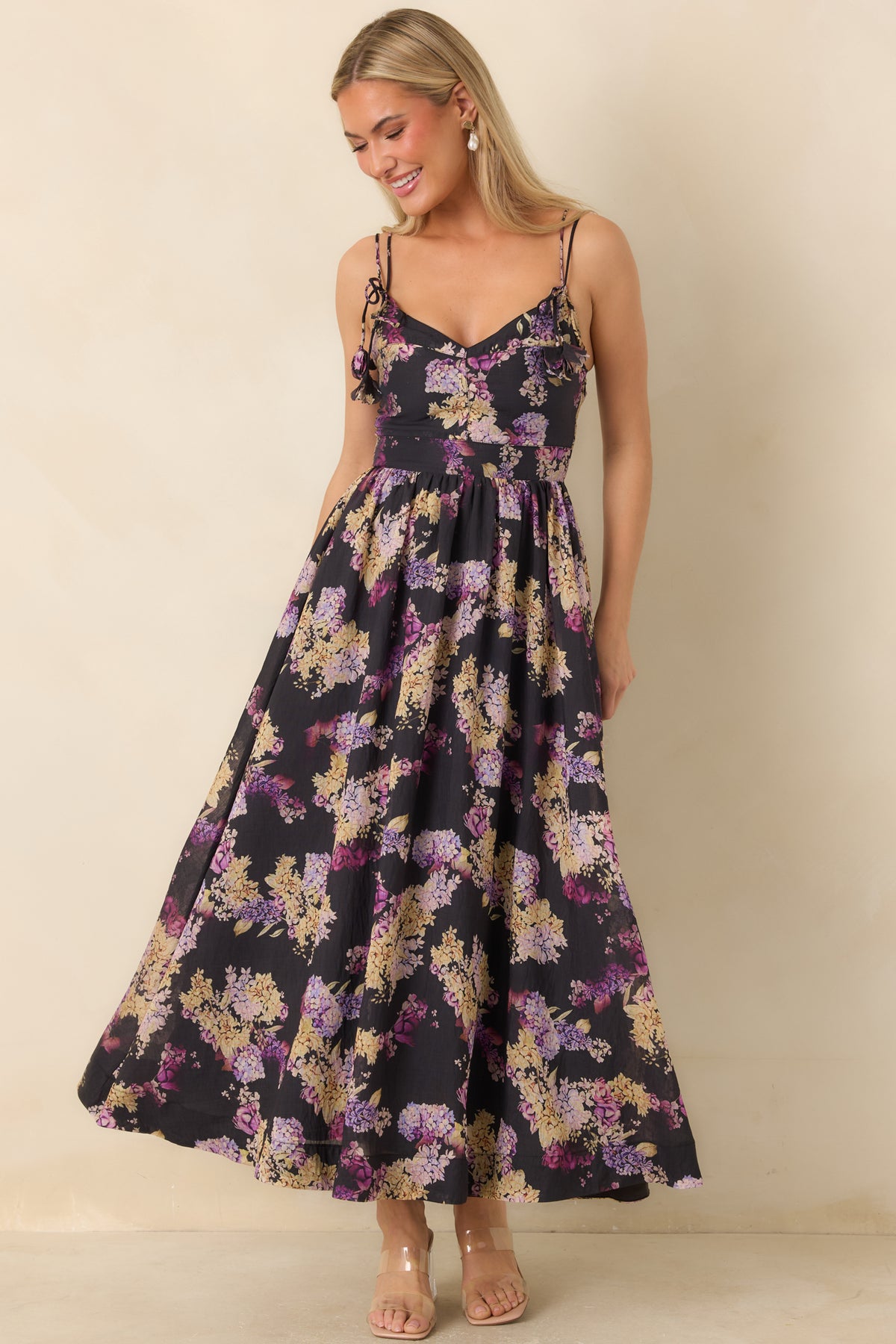 Pink, lilac, and yellow florals brighten this black midi dress with a fitted upper and softly flared skirt.