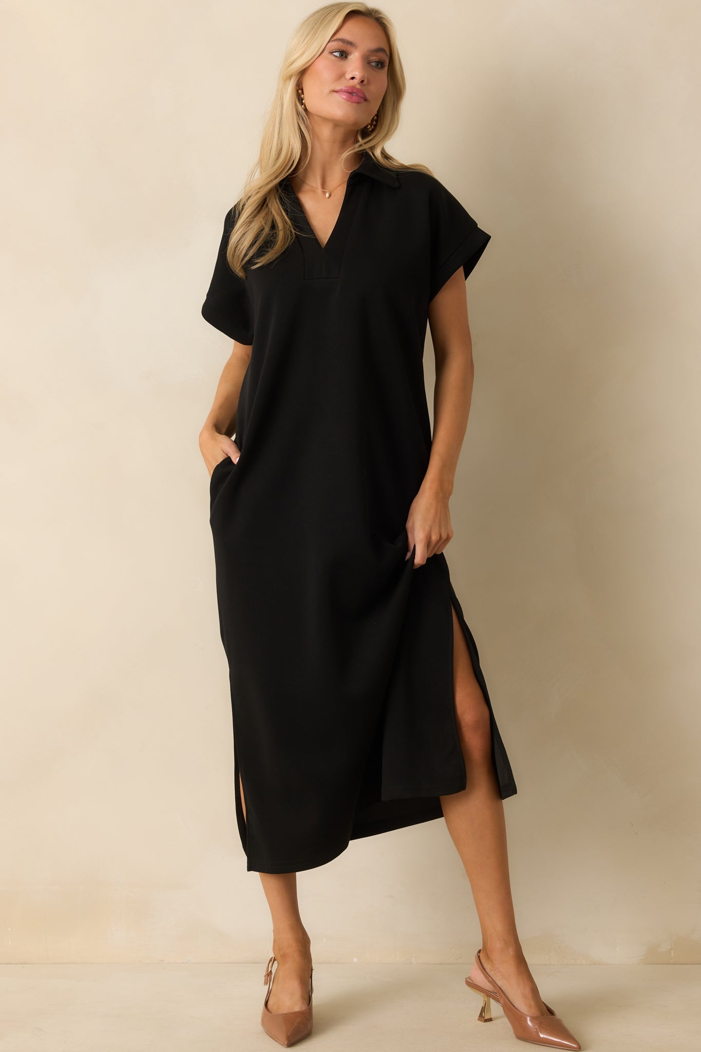 Black midi dress styled with functional pockets and an easy, relaxed fit.