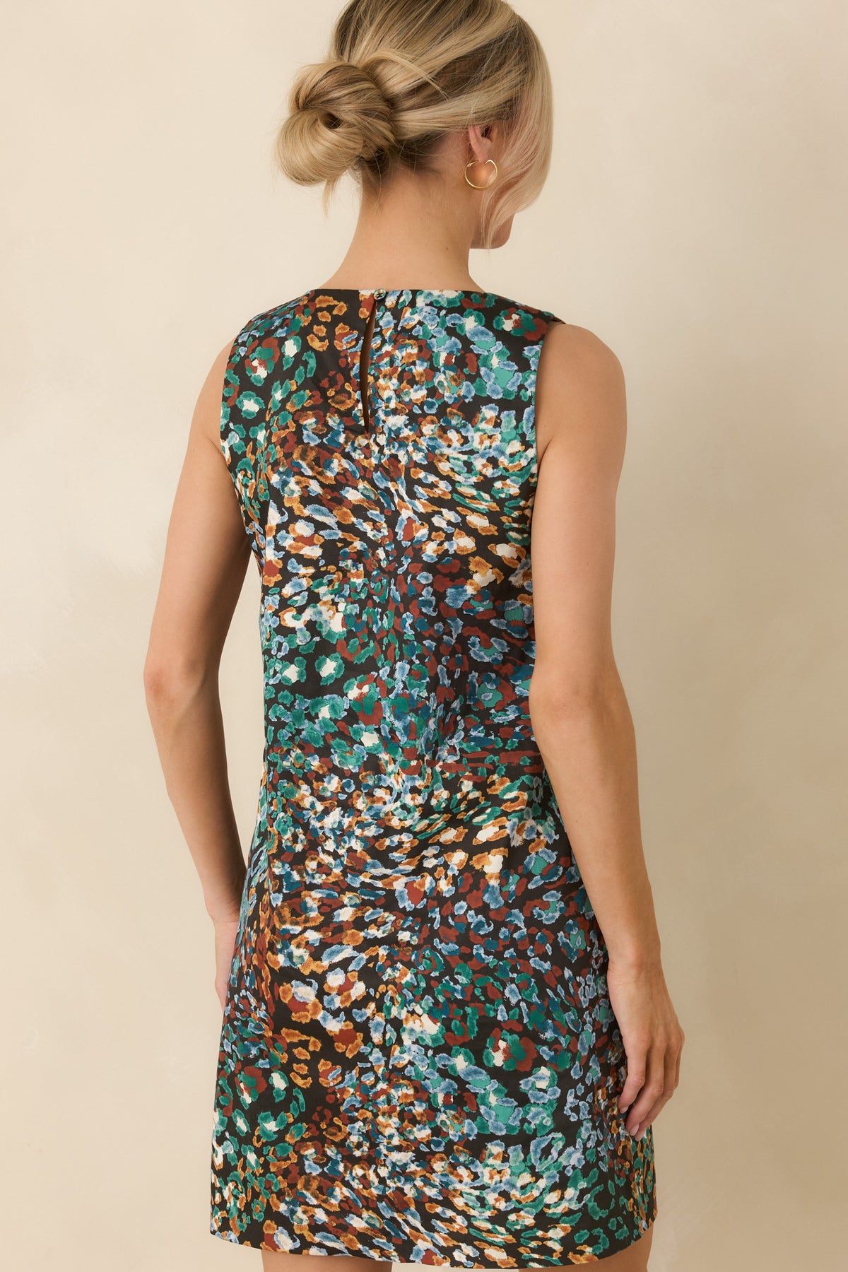 Black mini dress showcasing the rear keyhole and single button closure.