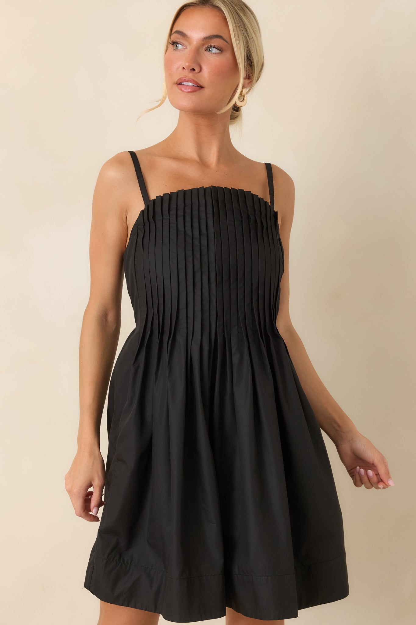 Black mini dress showcasing the gathered skirt detail and dimensional pleated design.