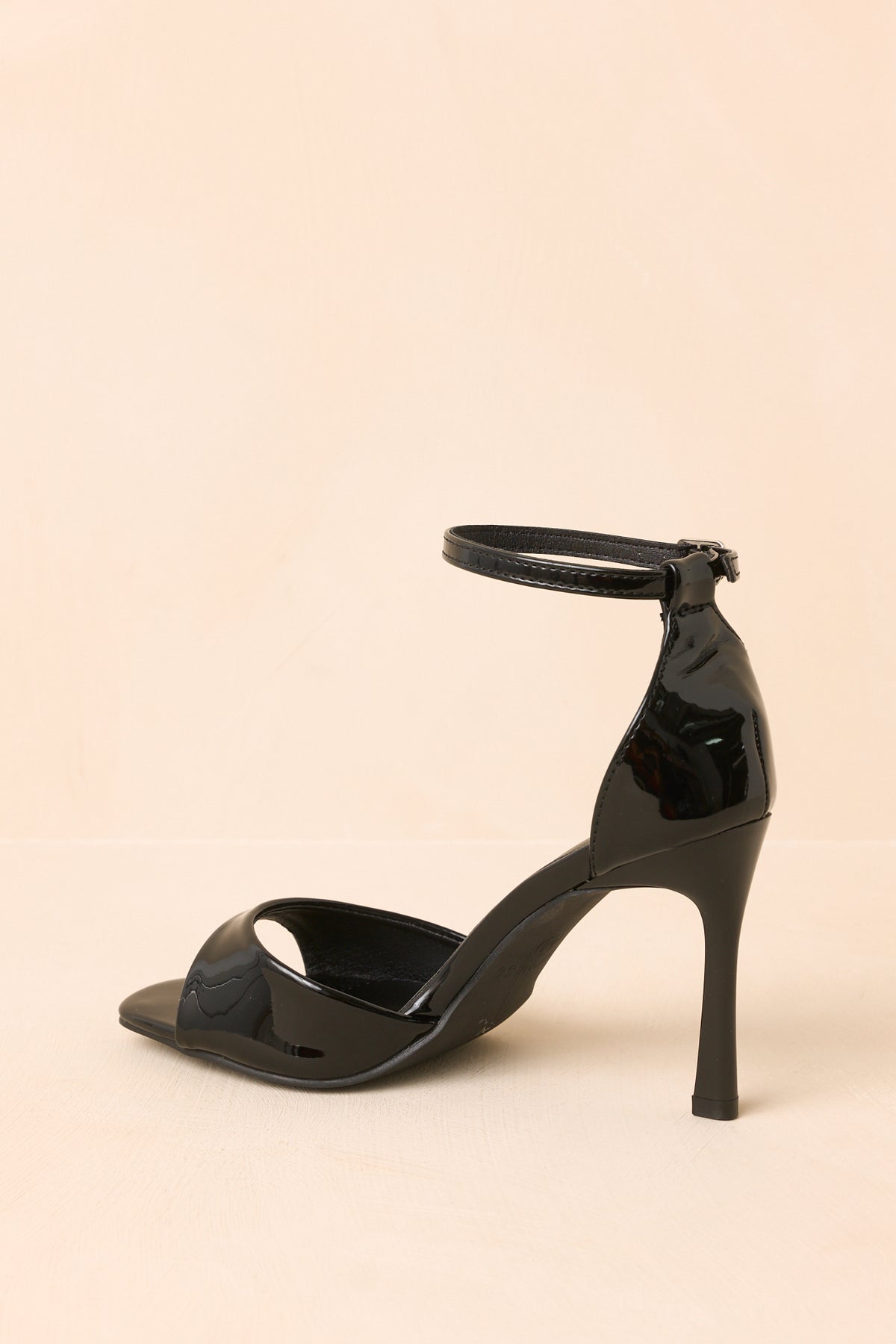 Black patent heels with a closed heel and adjustable ankle strap.