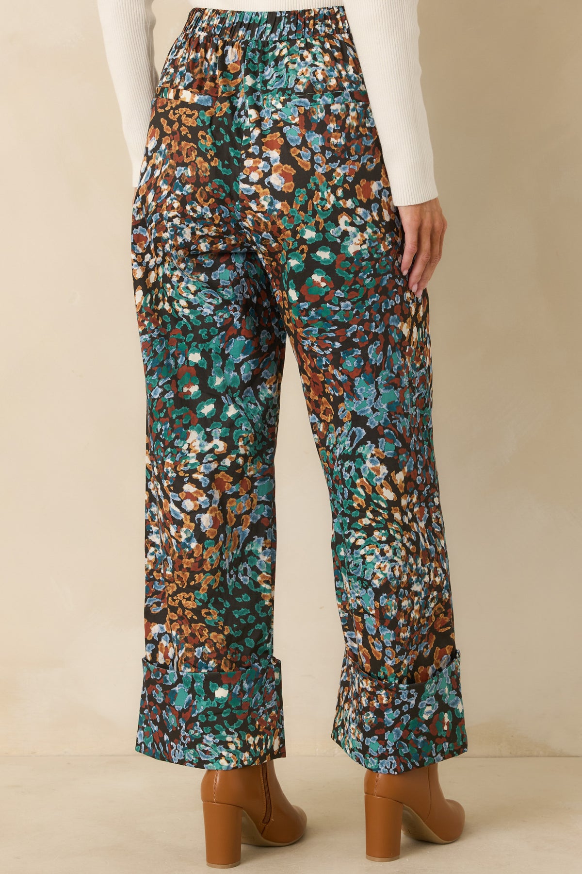 Black printed pants showcasing the sleek rear with faux welt pockets and cropped cuffs.