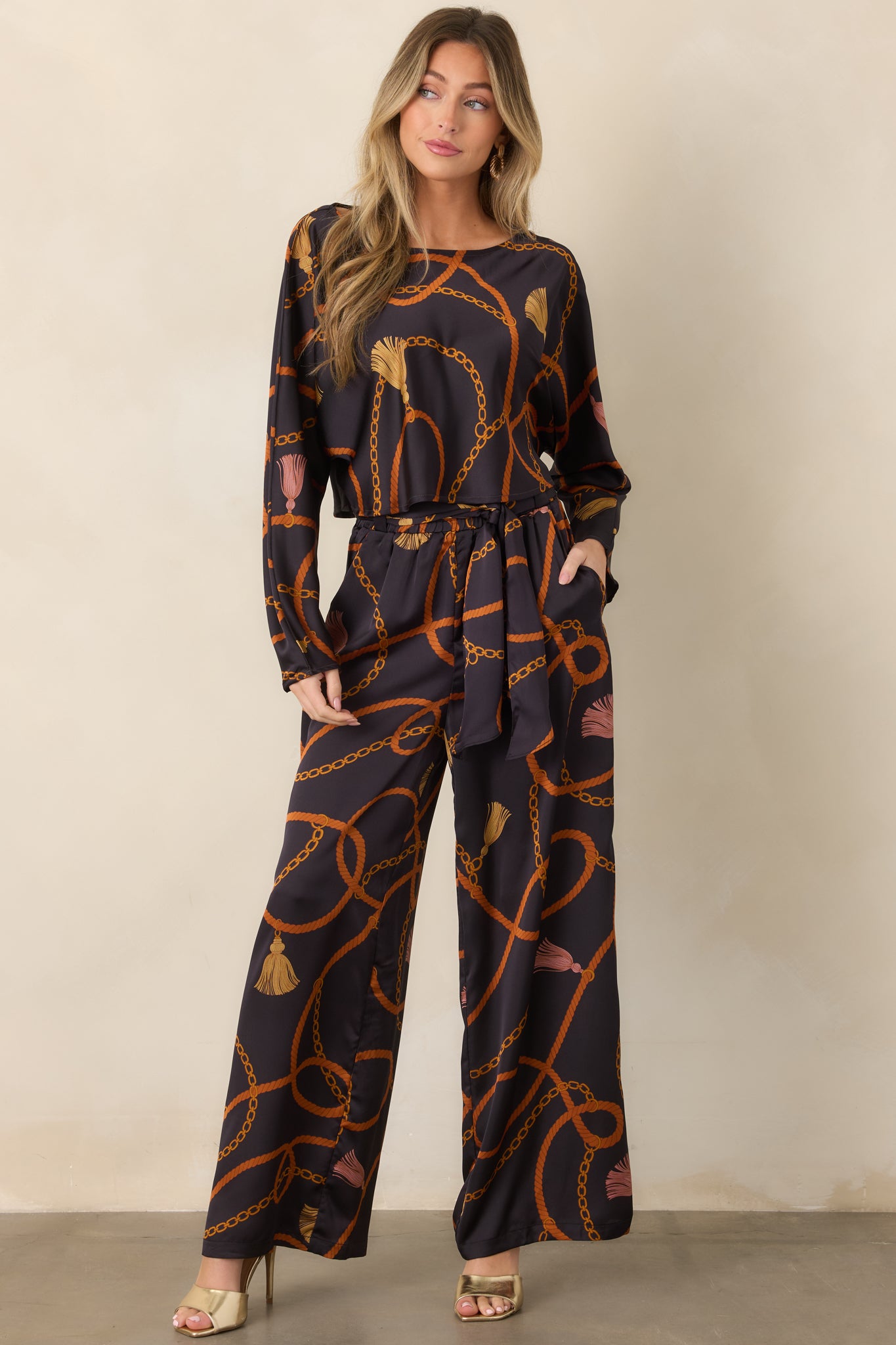 Printed wide-leg pants showcasing the fluid satin-feel fabric, functional side pockets, and coordinating scarf-tie belt.