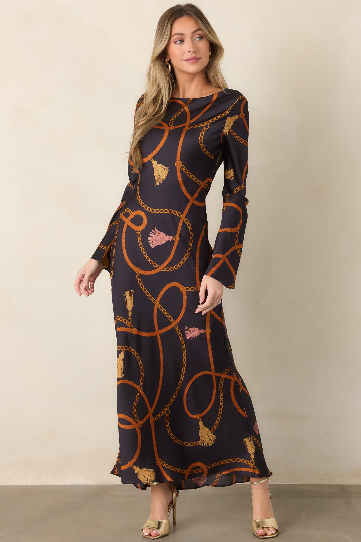 Pull-on maxi dress adorned with rust rope loops, golden chain motifs, and decorative tassel accents.