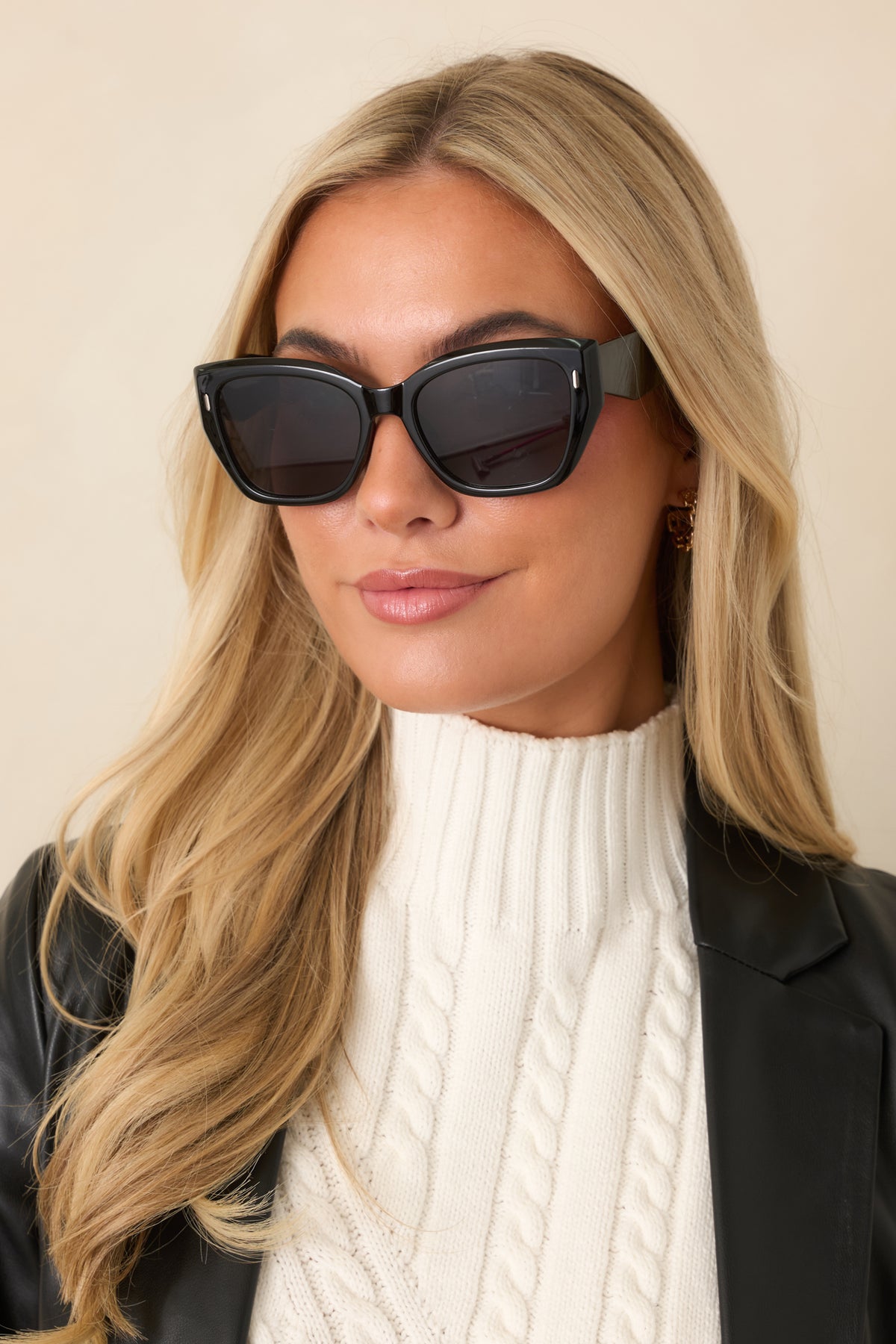 Retro-inspired black sunglasses showcase dark lenses, angular square frames, and thick temples with subtle gold-tone detailing.