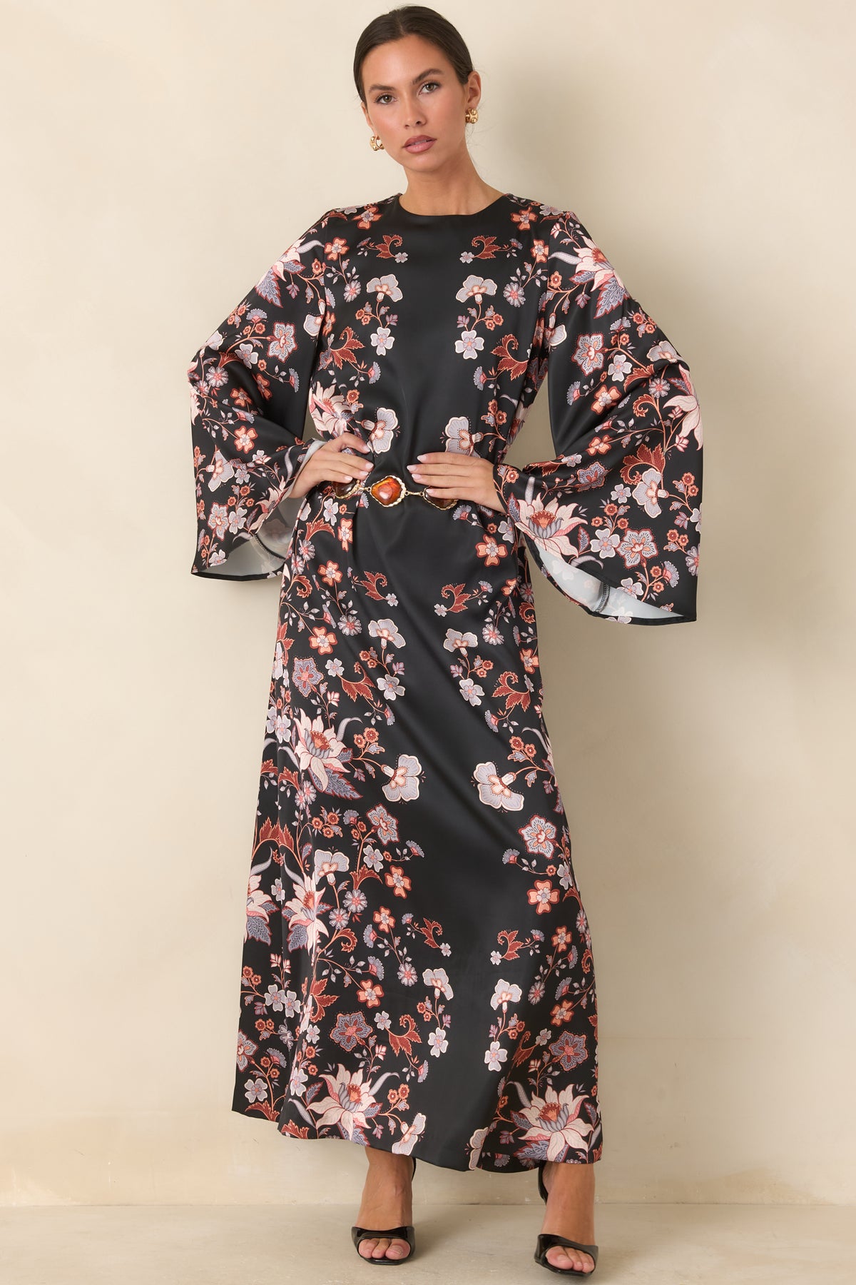 Black satin dress featuring blush pink and ivory blooms across its relaxed shape.
