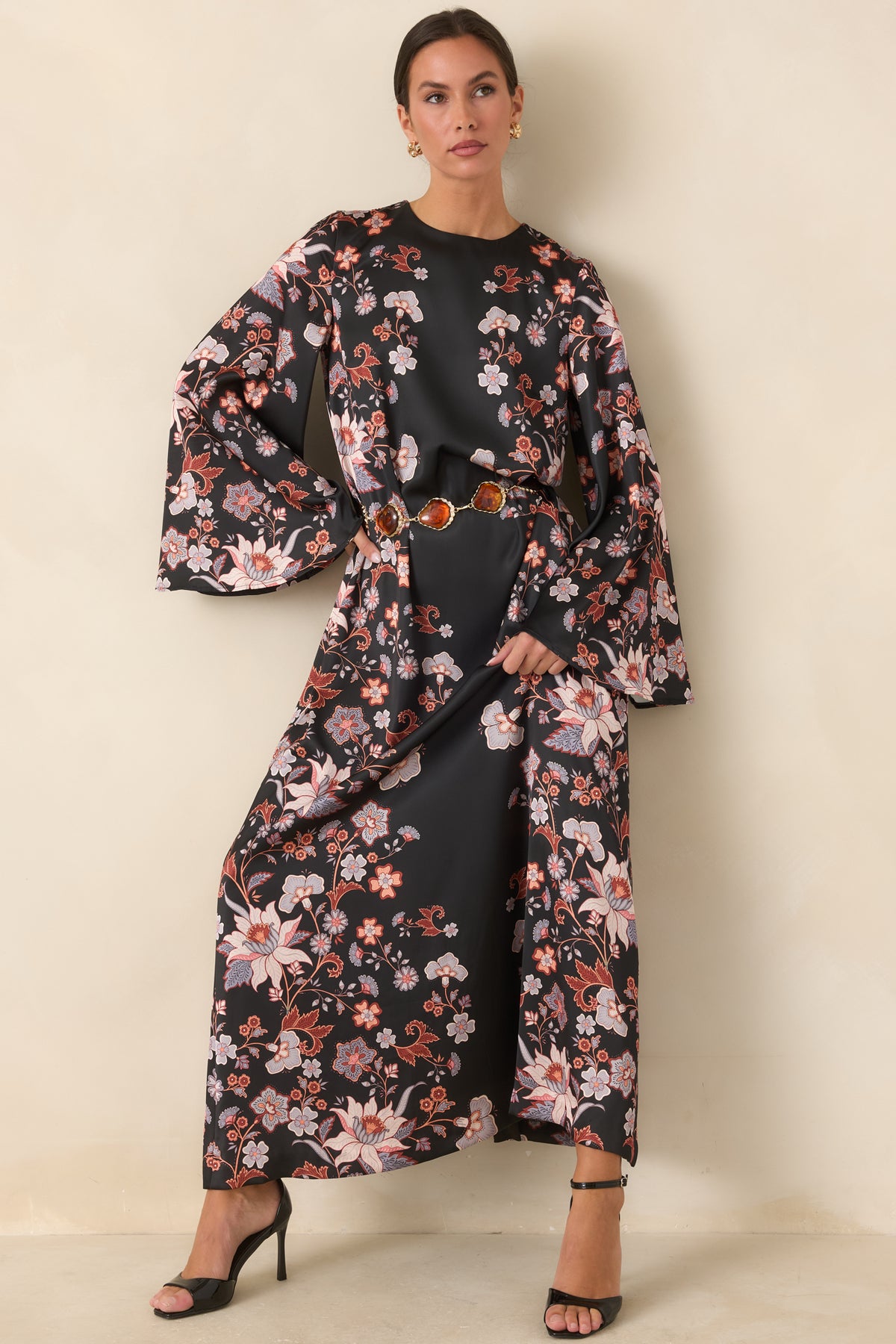 Black satin maxi dress featuring trailing blooms in blush pink, ivory, rust, and muted blue.