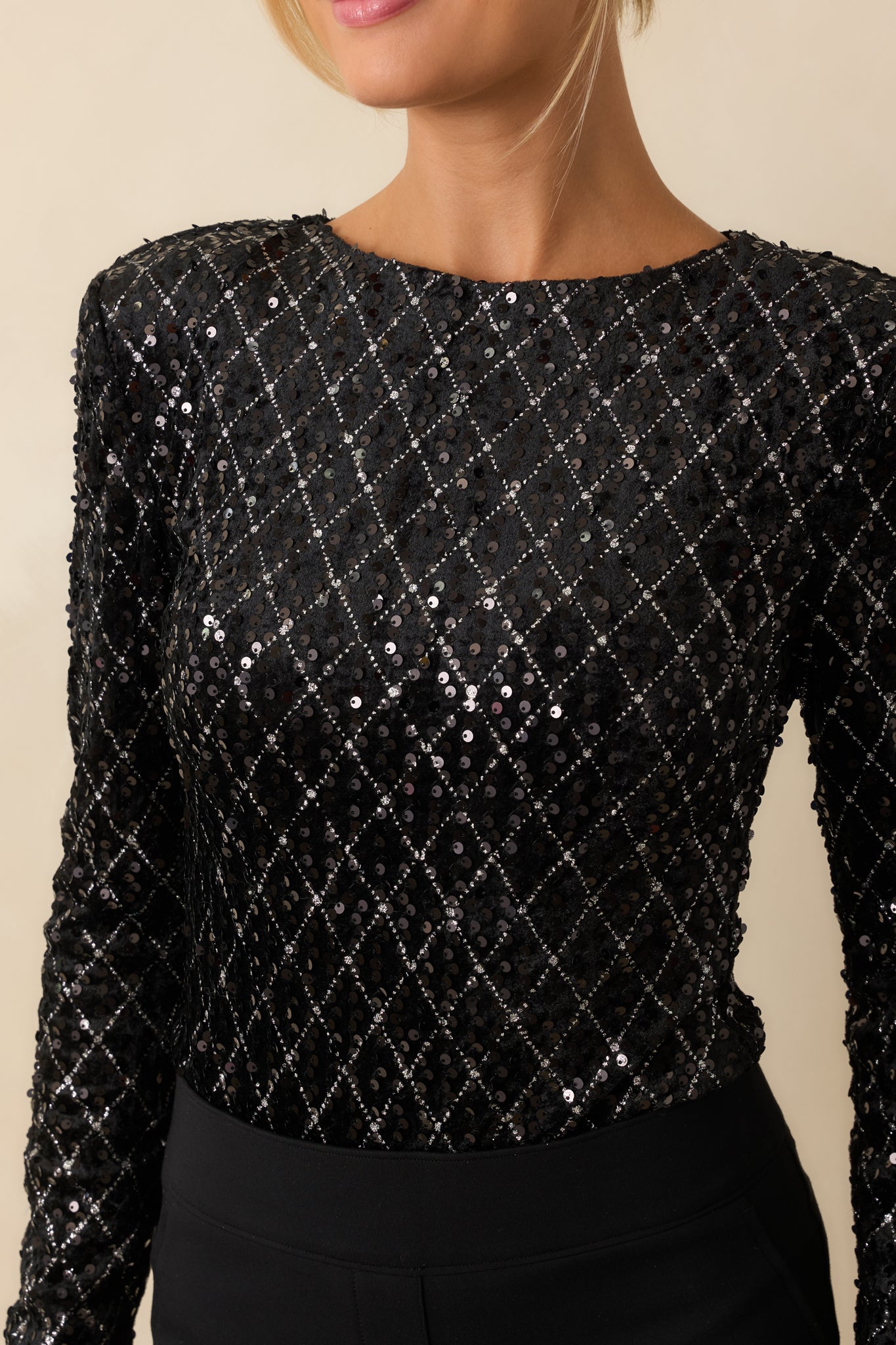 Detailed shot of the black sequins and precise stitching on the bodice and neckline for a refined finish.