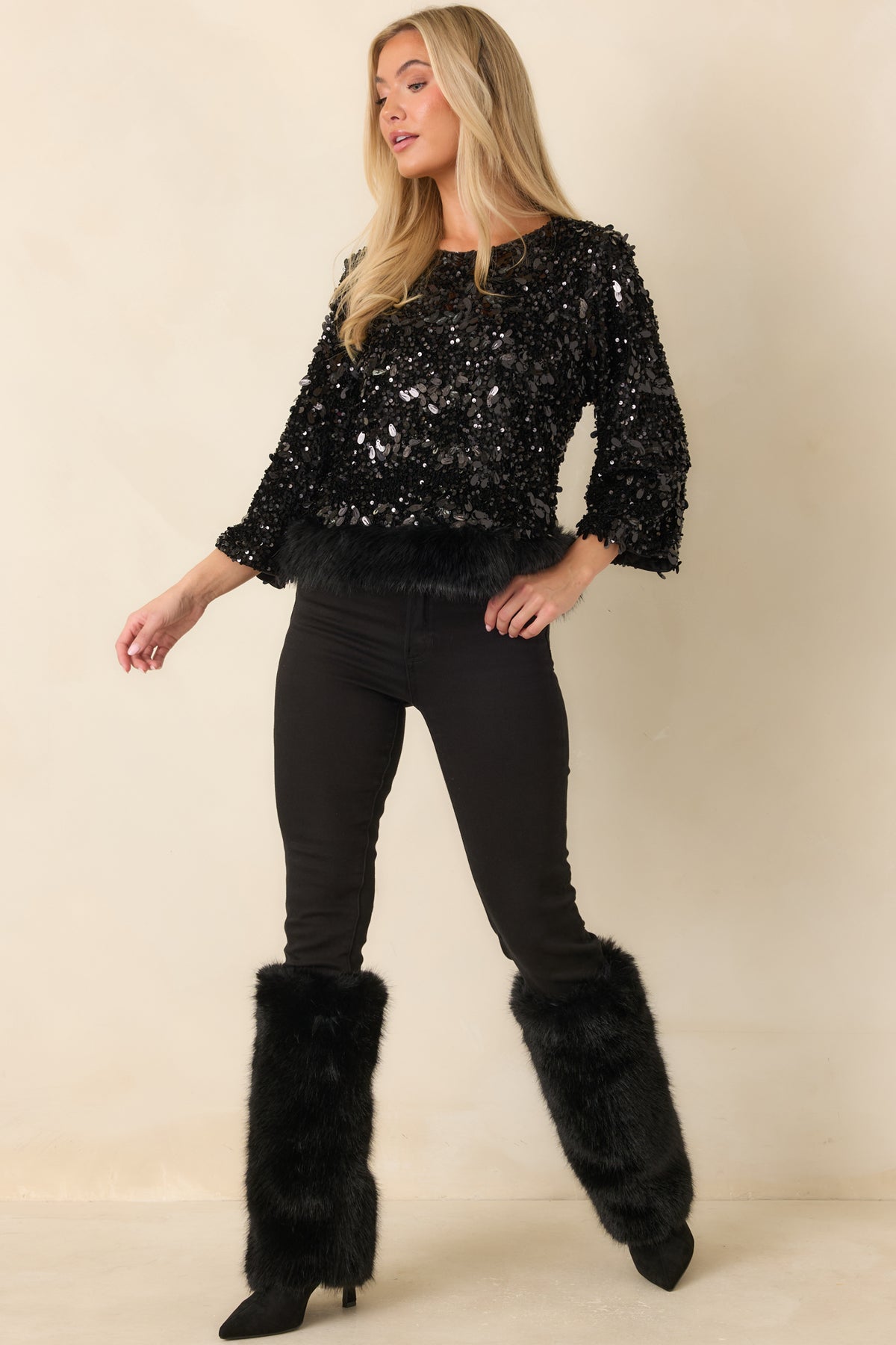 Round neckline framed by shimmering black sequins on the relaxed top.