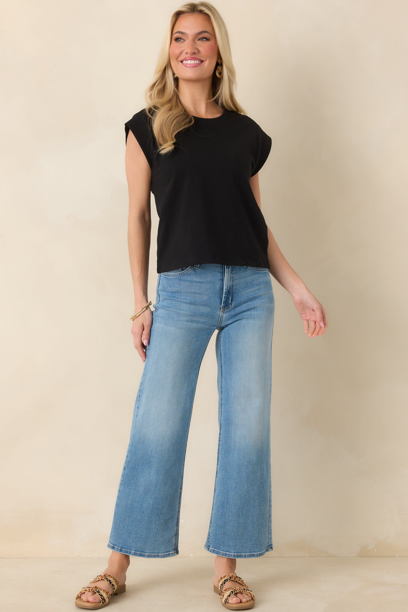 Full view of black short sleeve top highlighting relaxed fit and modern, clean shape.