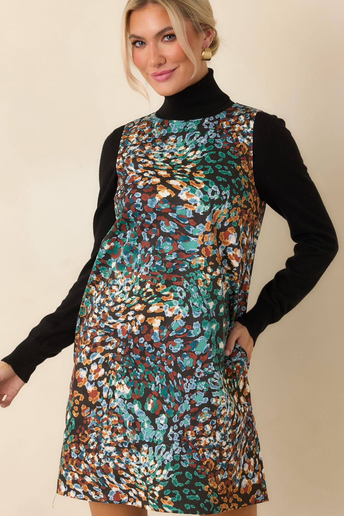 Black mini dress highlighting the sleeveless cut and clean round neckline.